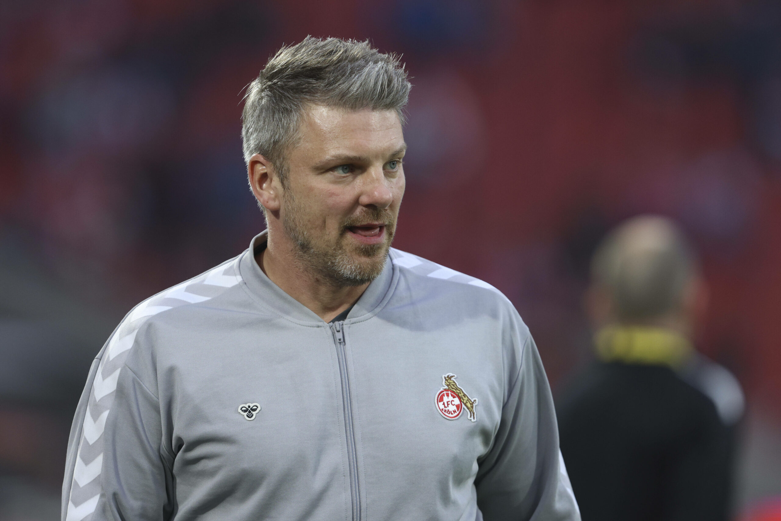 Lukas Kwasniok schaut in einem Trainingsanzug des 1. FC Köln nach rechts.