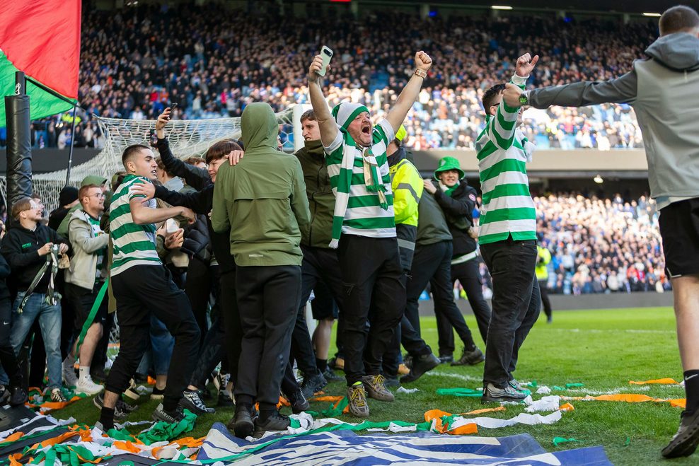 Fans von Celtic Glasgow stürmen den Platz und jubeln neben dem Tor.