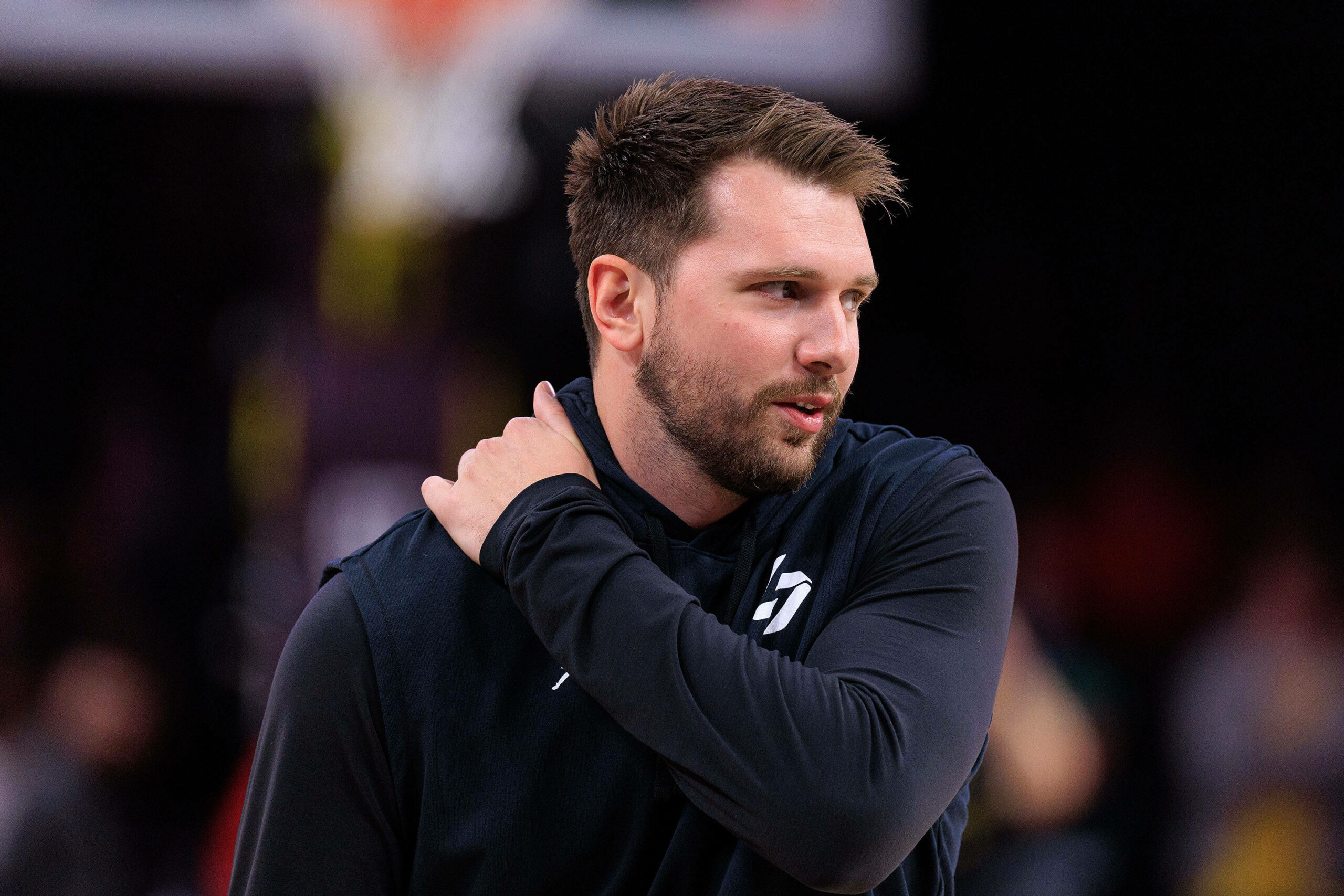 Luka Doncic schaut zur Seite und greift sich mit dem linken Arm an die rechte Schulter.