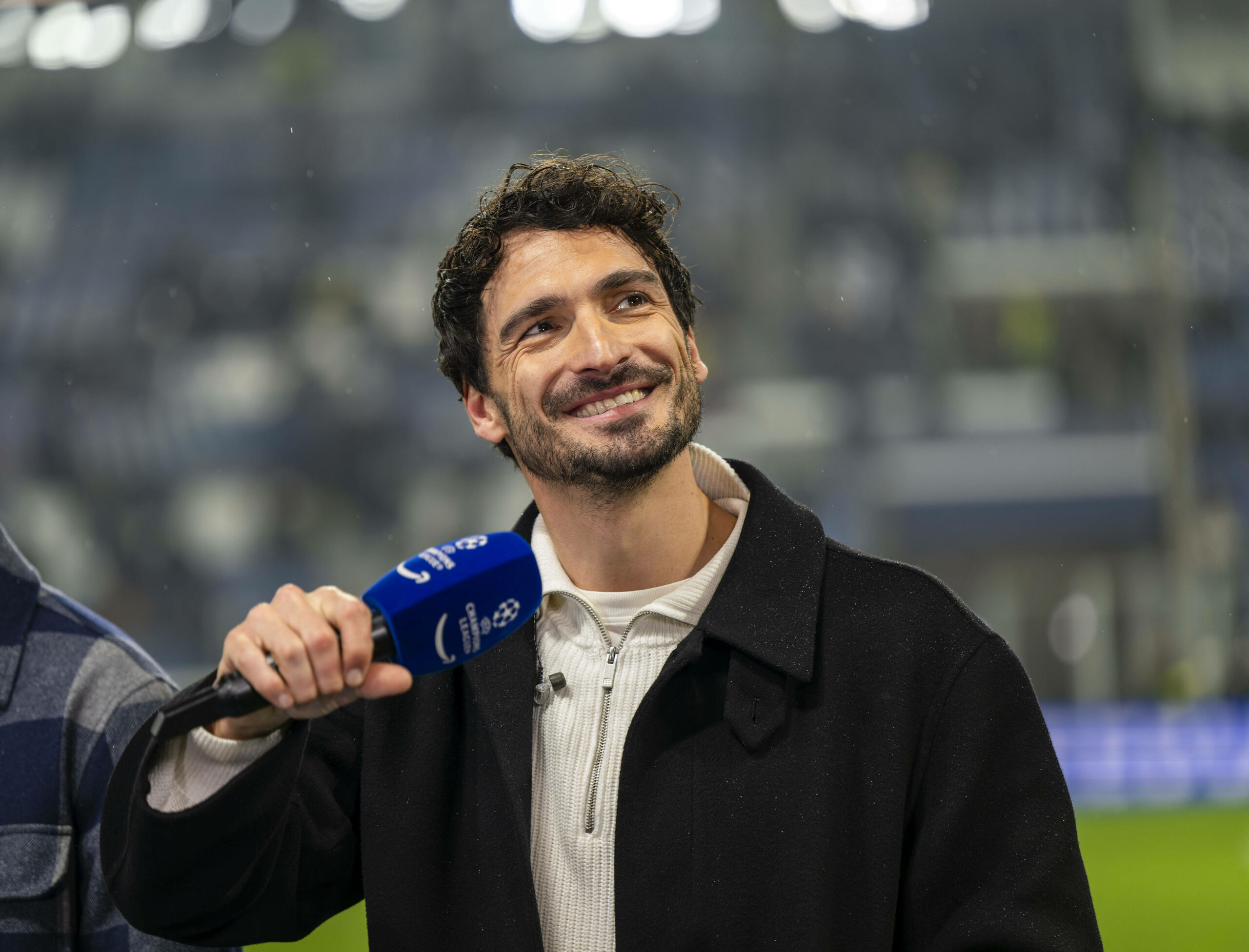 Mats Hummels gut gelaunt mit einem Mikrofon