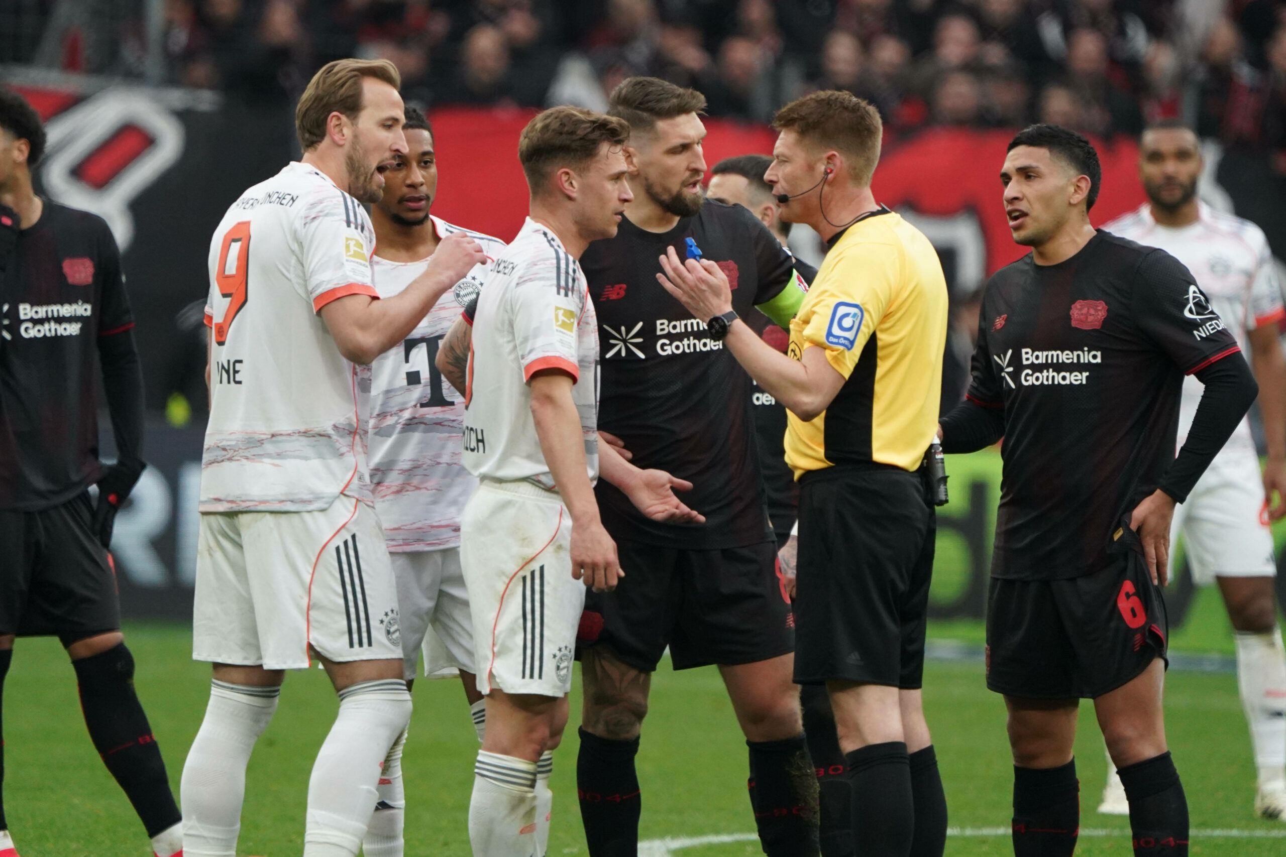 Spieler des FC Bayern und Leverkusen diskutieren mit dem Schiedsrichter