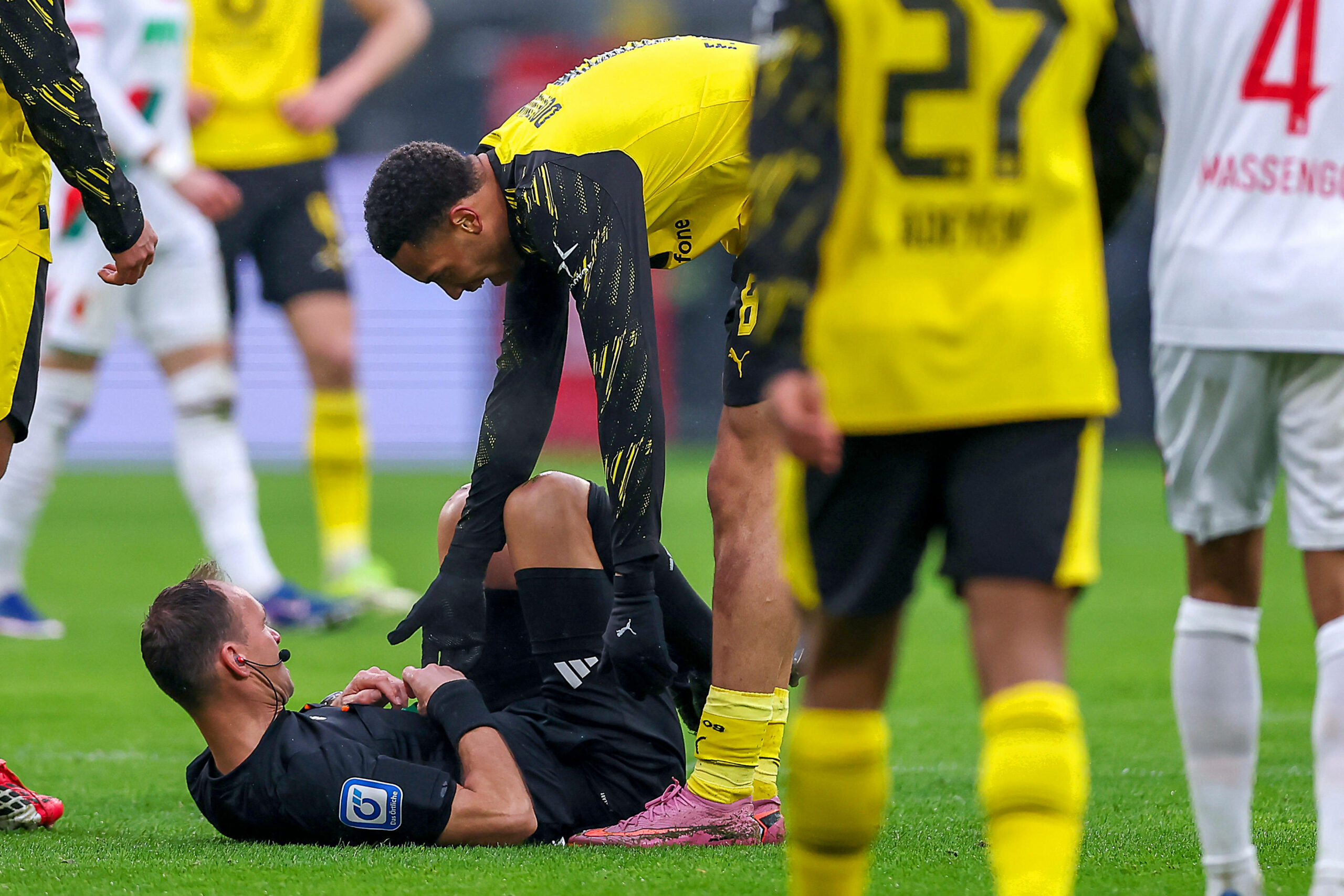 Nmecha (r) hilft dem Schiedsrichter hoch