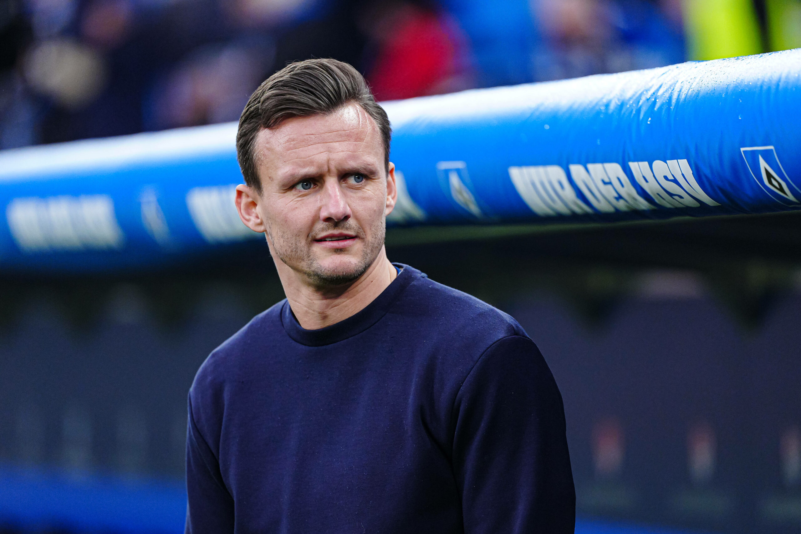 HSV-Sportdirektor Claus Costa steht vor einem Spiel seiner Mannschaft vor der Ersatzbank.