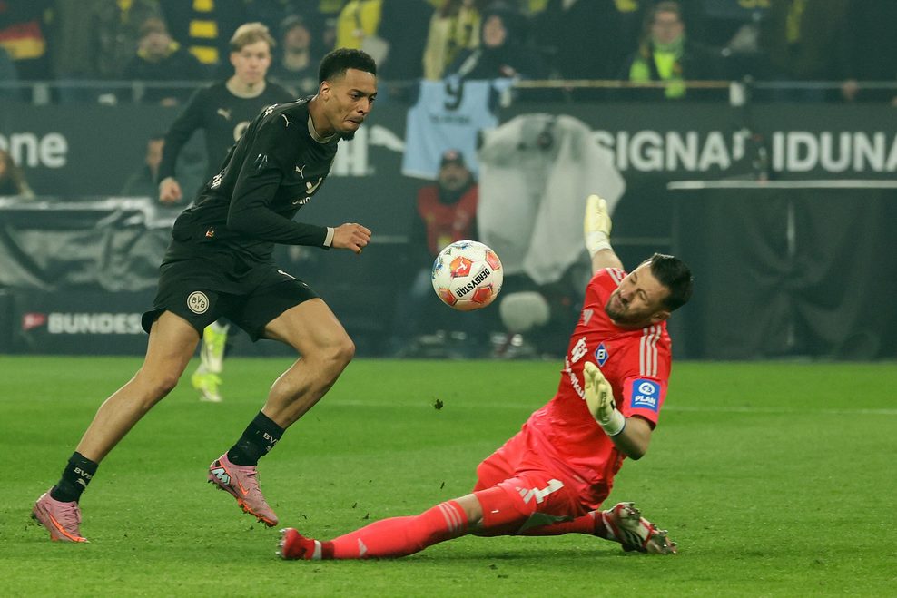 HSV-Torwart Daniel Heuer Fernandes (r.) klärt in höchster Not gegen Dortmunds Felix Nmecha.