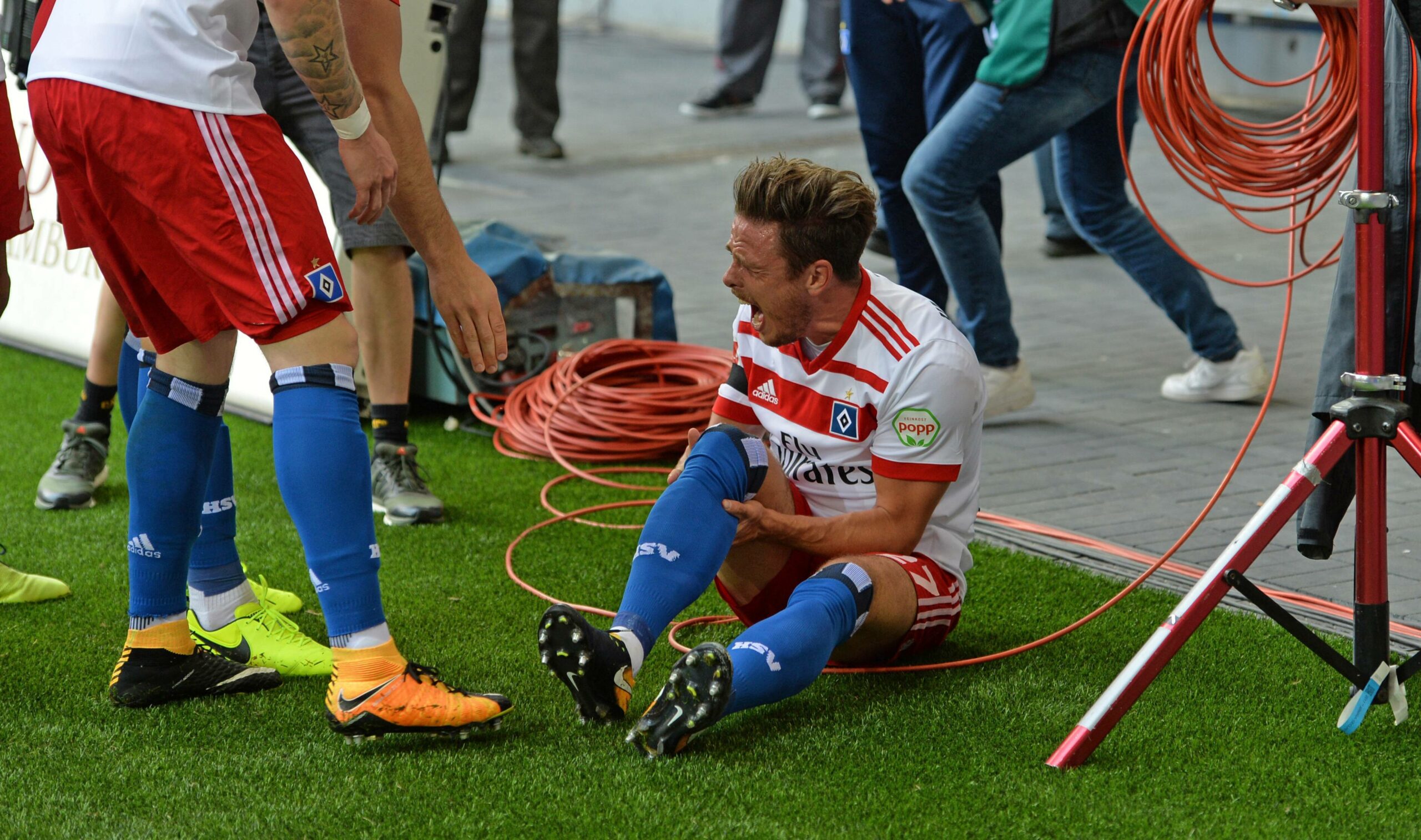 Nicolai Müller sitzt auf dem Spielfeld und schreit vor Schmerzen