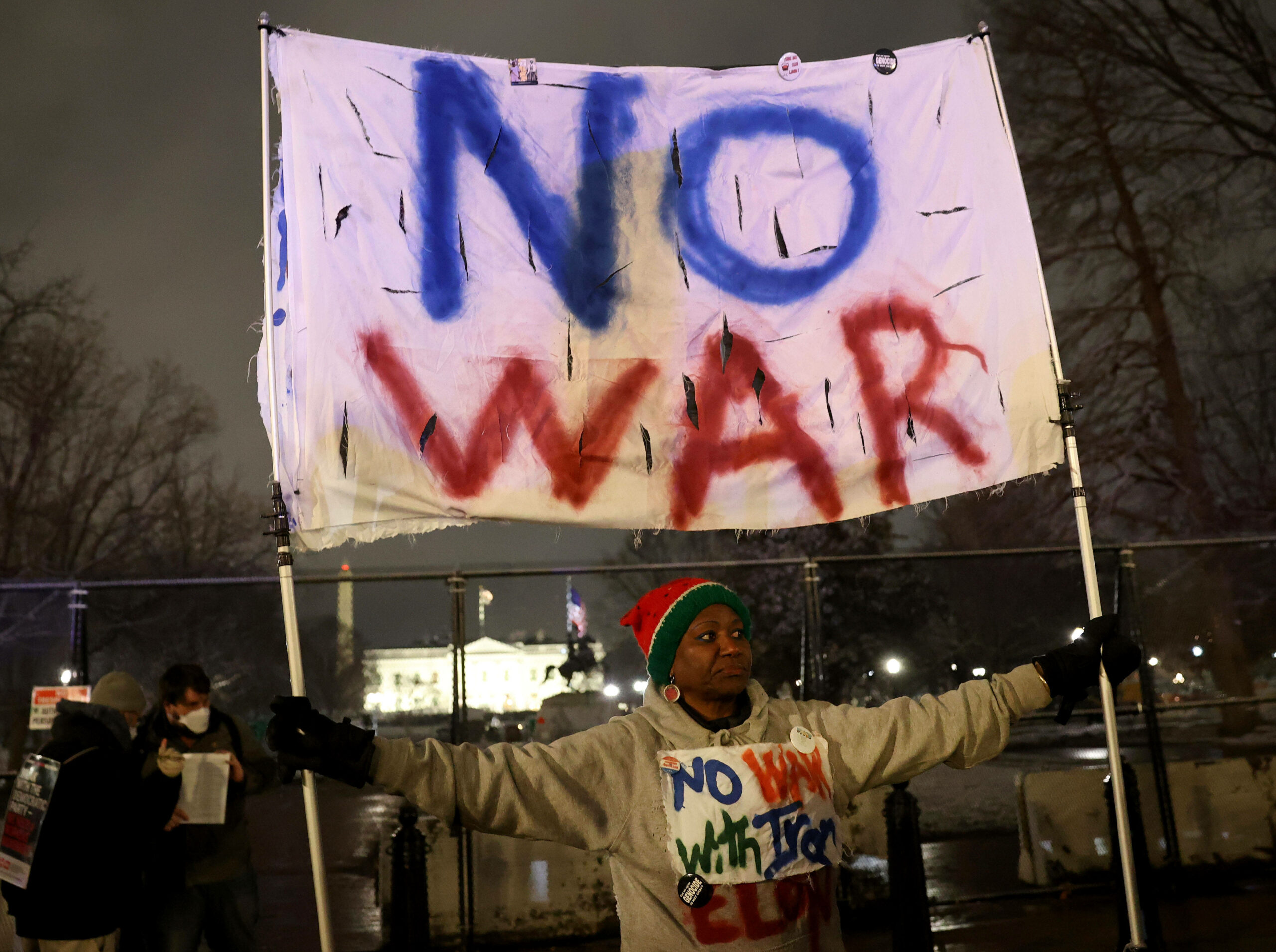 Ein Plakat mit der Aufschrift „No War“ wird hochgehalten