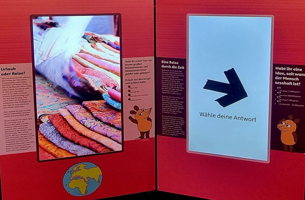 Eine Station der Ausstellung mit zwei großen Bildschirmen