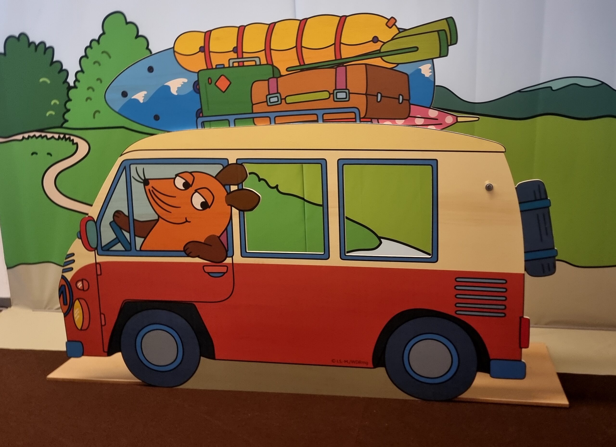 Ein Aufsteller der Maus, die einen Bus fährt.