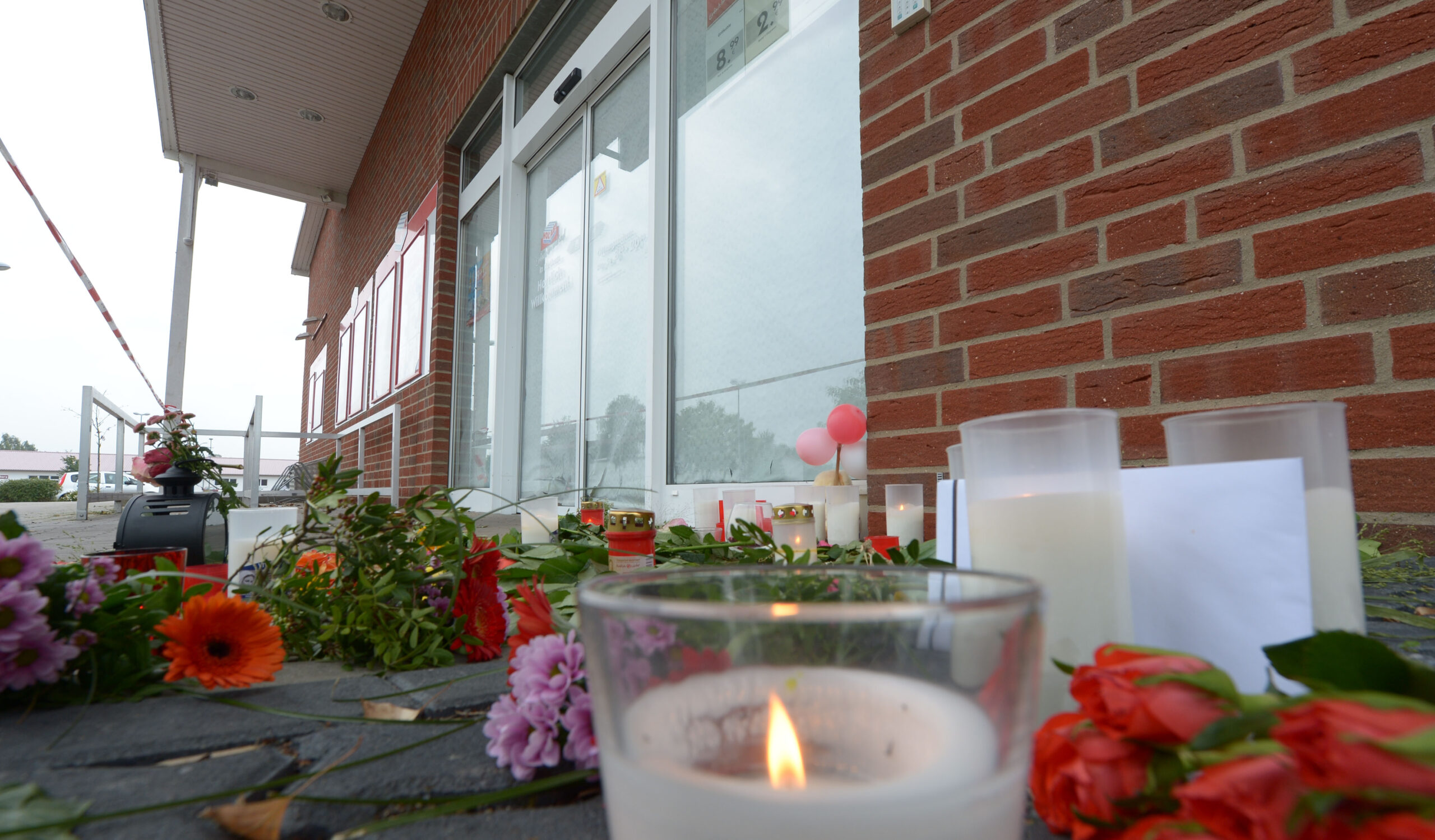 Nach Mord mit 120 Messerstichen: Blumen, Kerzen und kleine Briefchen liegen am 20.09.2013 vor einem Getränkemarkt in Rethem bei Soltau (Niedersachsen). (Archivbild)