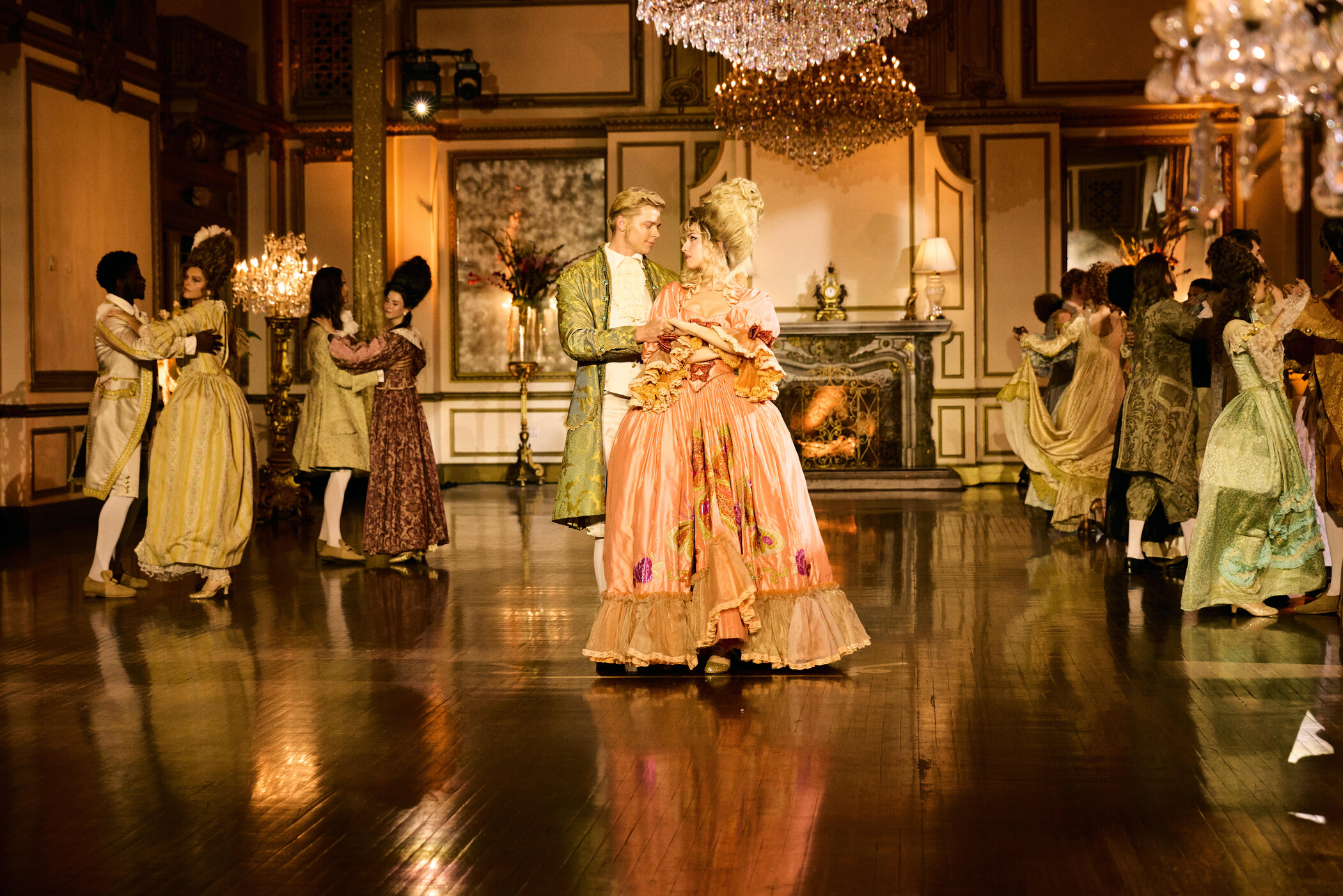 Anna und Yanneck stehen Hand in Hand im Ballsaal in ihren Kostümen.