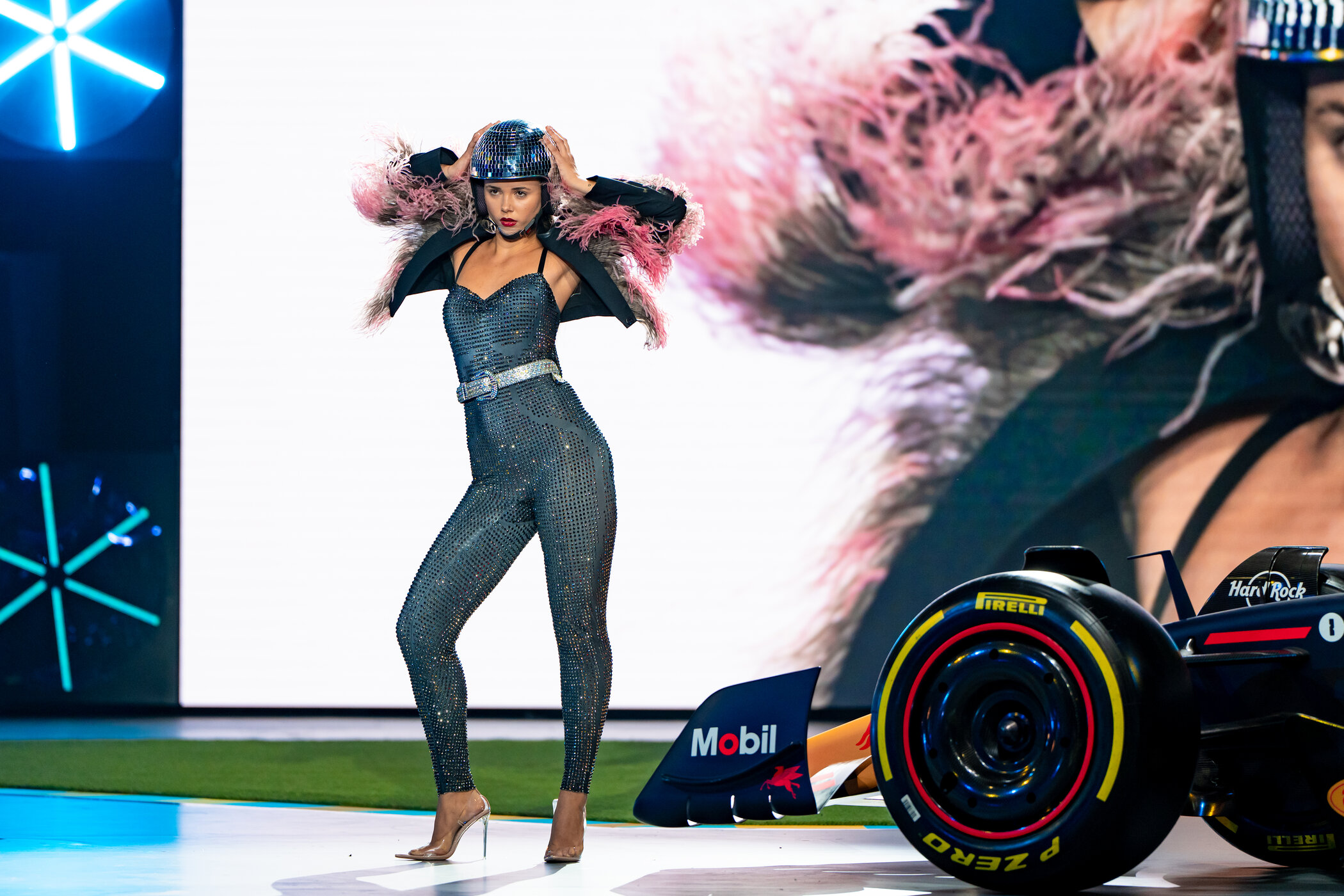 Kandidatin Lola (19) steht auf dem Laufsteg, die Hände am Glitzerhelm.