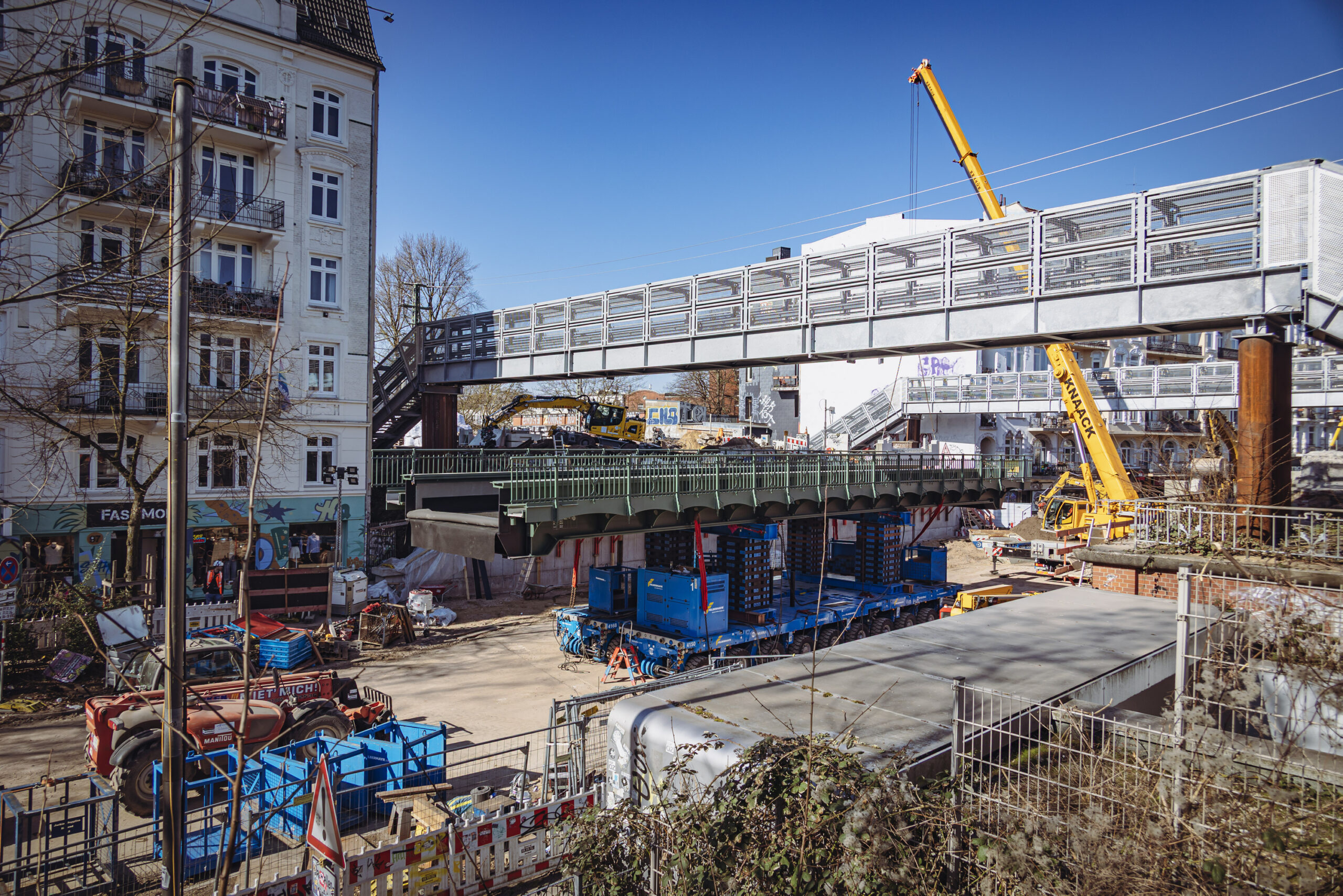 Die neue Bahnbrücke wird Stück für Stück hochgehievt, anschließend dann gedreht und an die bestehenden Gleise angedockt.