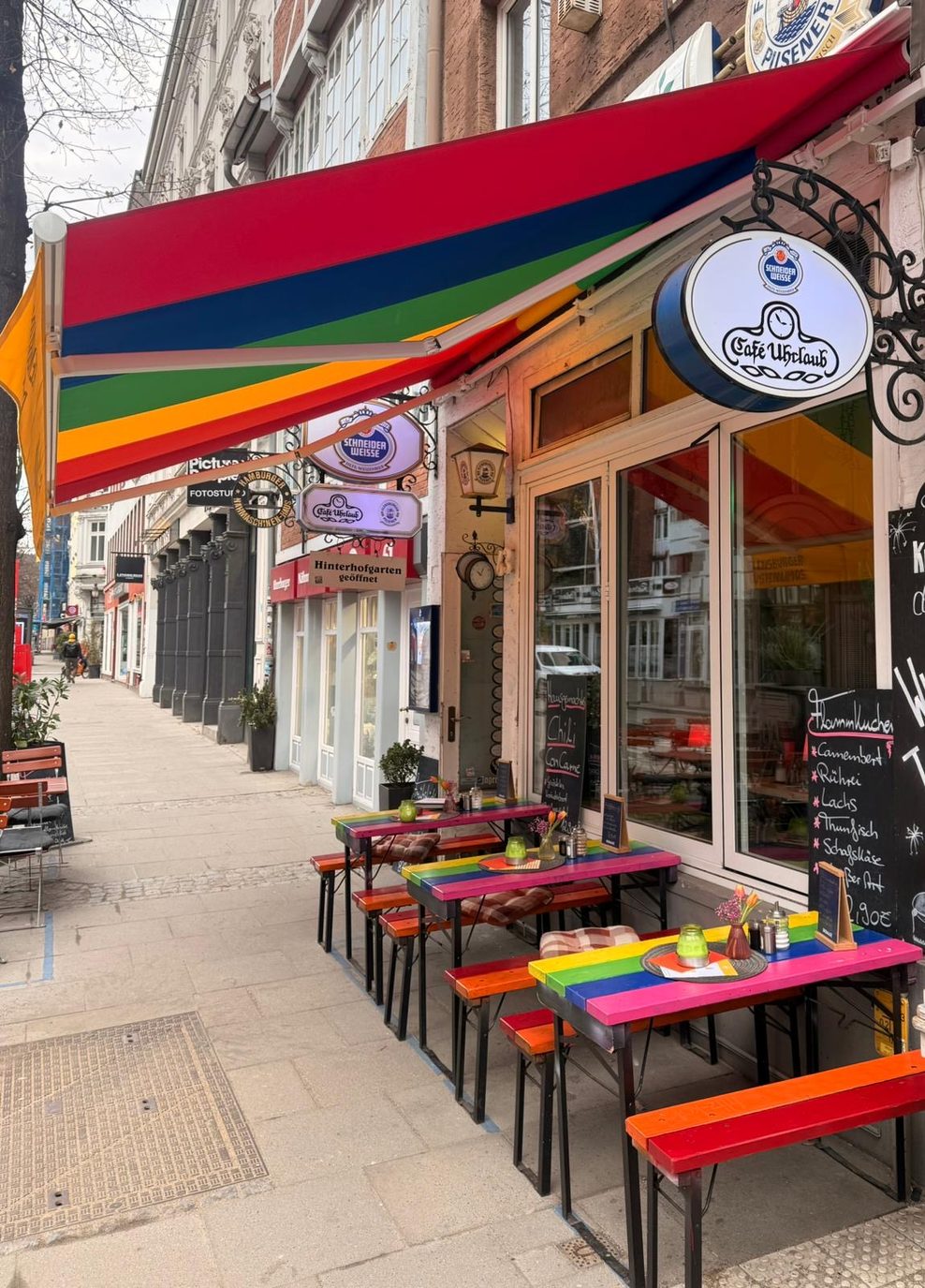 Auch die Tische und Bänke vor dem „Café Uhrlaub“ haben nun Regenbogen-Farben.