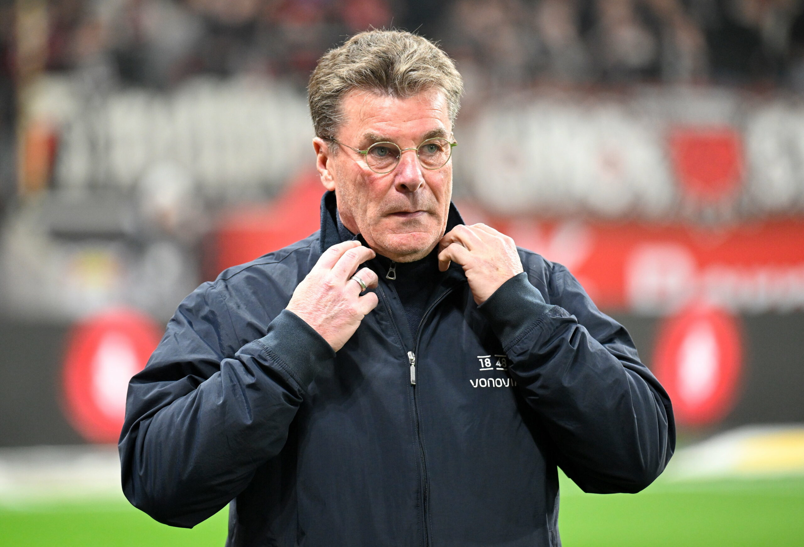 Dieter Hecking fasst sich an den Kragen seiner Bochum-Jacke.