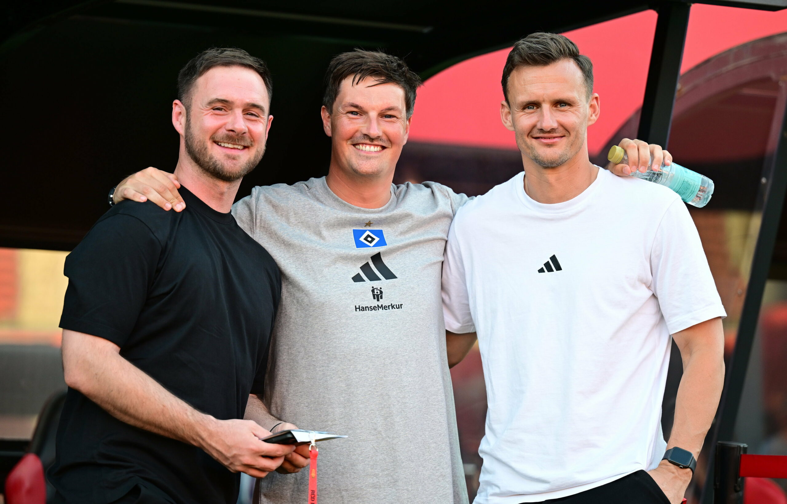 Sebastian Dirscherl, Merlin Polzin und Claus Costa lächeln Arm in Arm