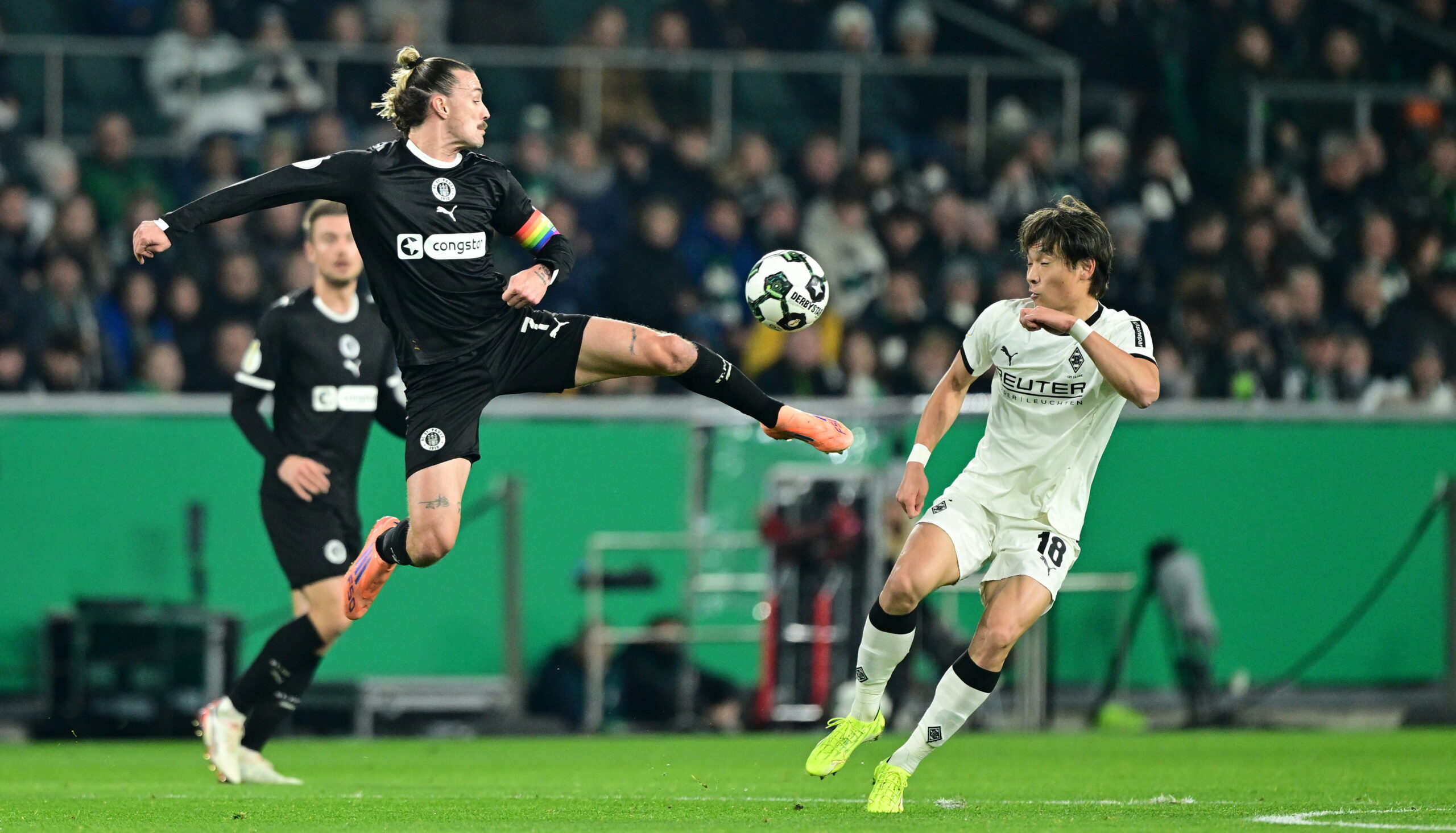 St. Pauli-Profi Jackson Irvine im Zweikampf mit Shuto Machino von Borussia Mönchengladbach