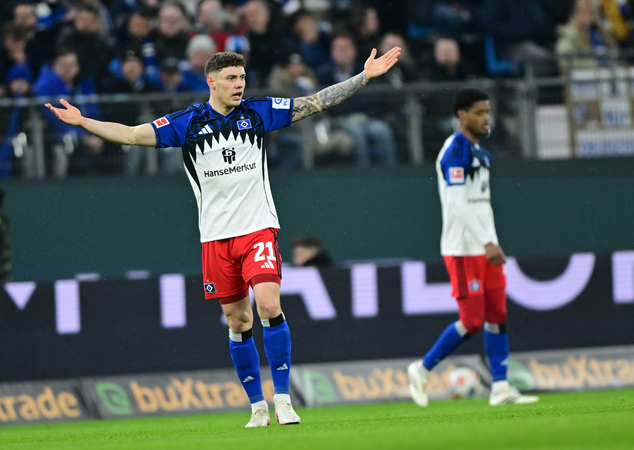 Nicolai Remberg steht mit ausgebreiteten Armen auf dem Platz.