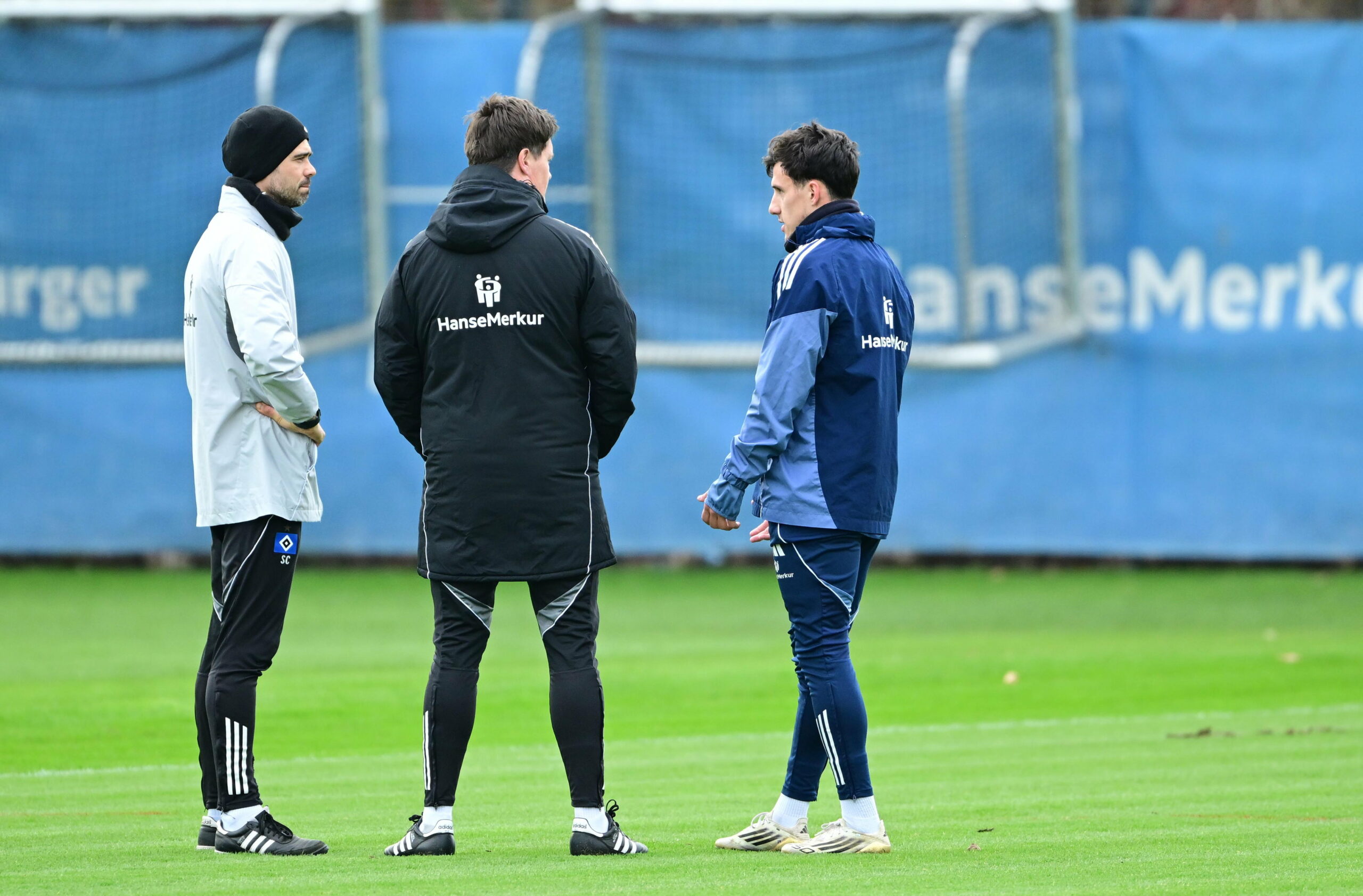 Reha-Trainer Sebastian Capel und Chefcoach Merlin Polzin im Gespräch mit Nicolás Capaldo