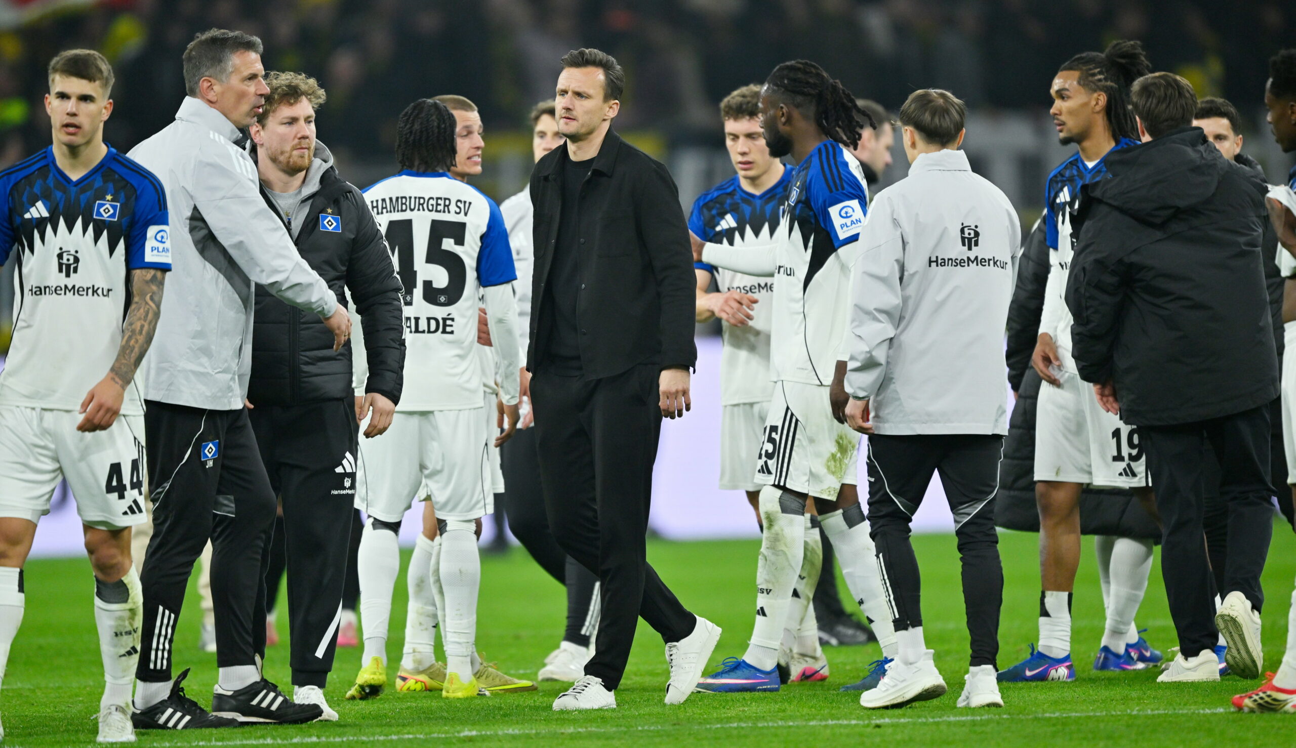 Claus Costa neben den HSV-Profis in Dortmund