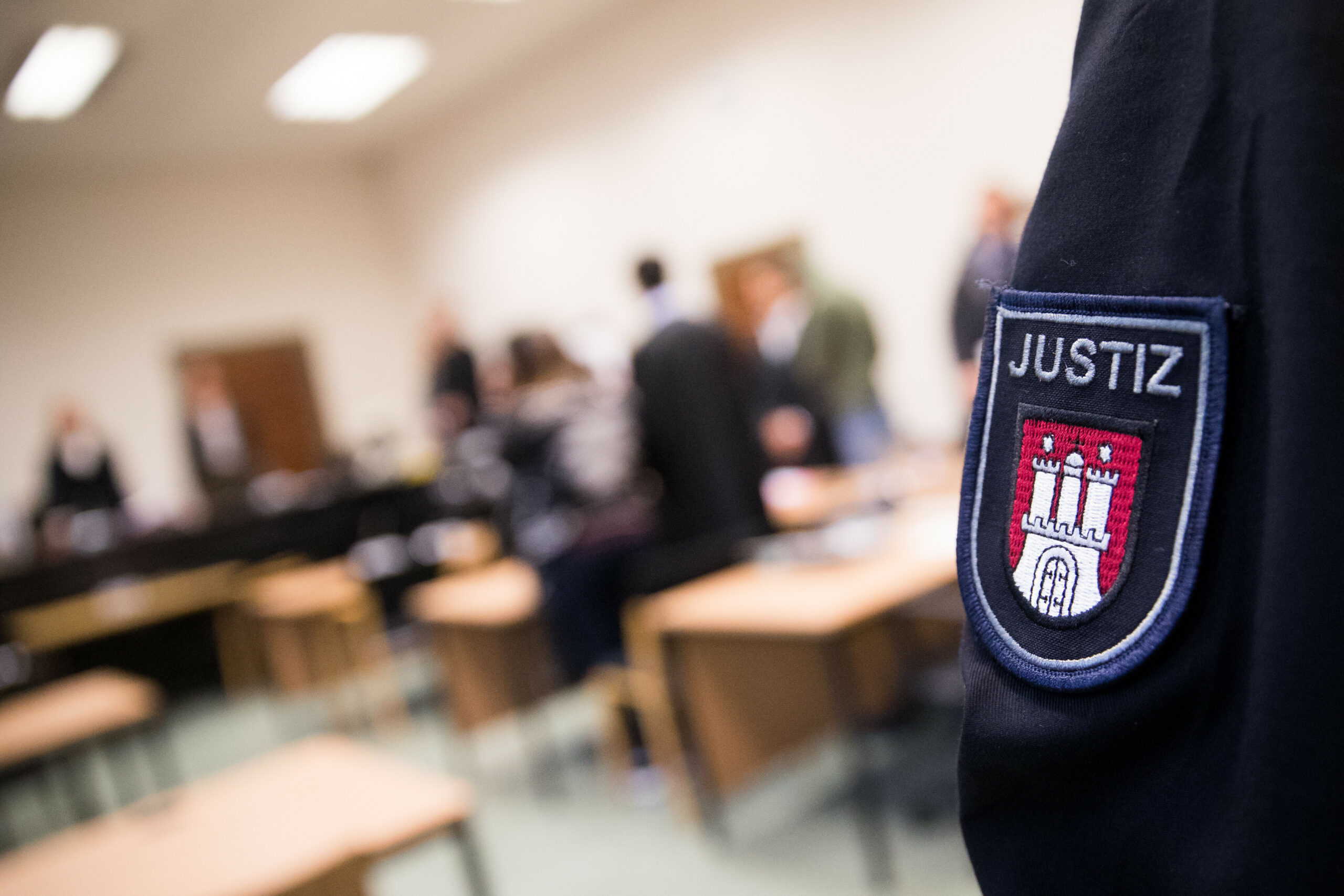Justizbeamter steht vor Prozessbeginn in einem Gerichtssaal.