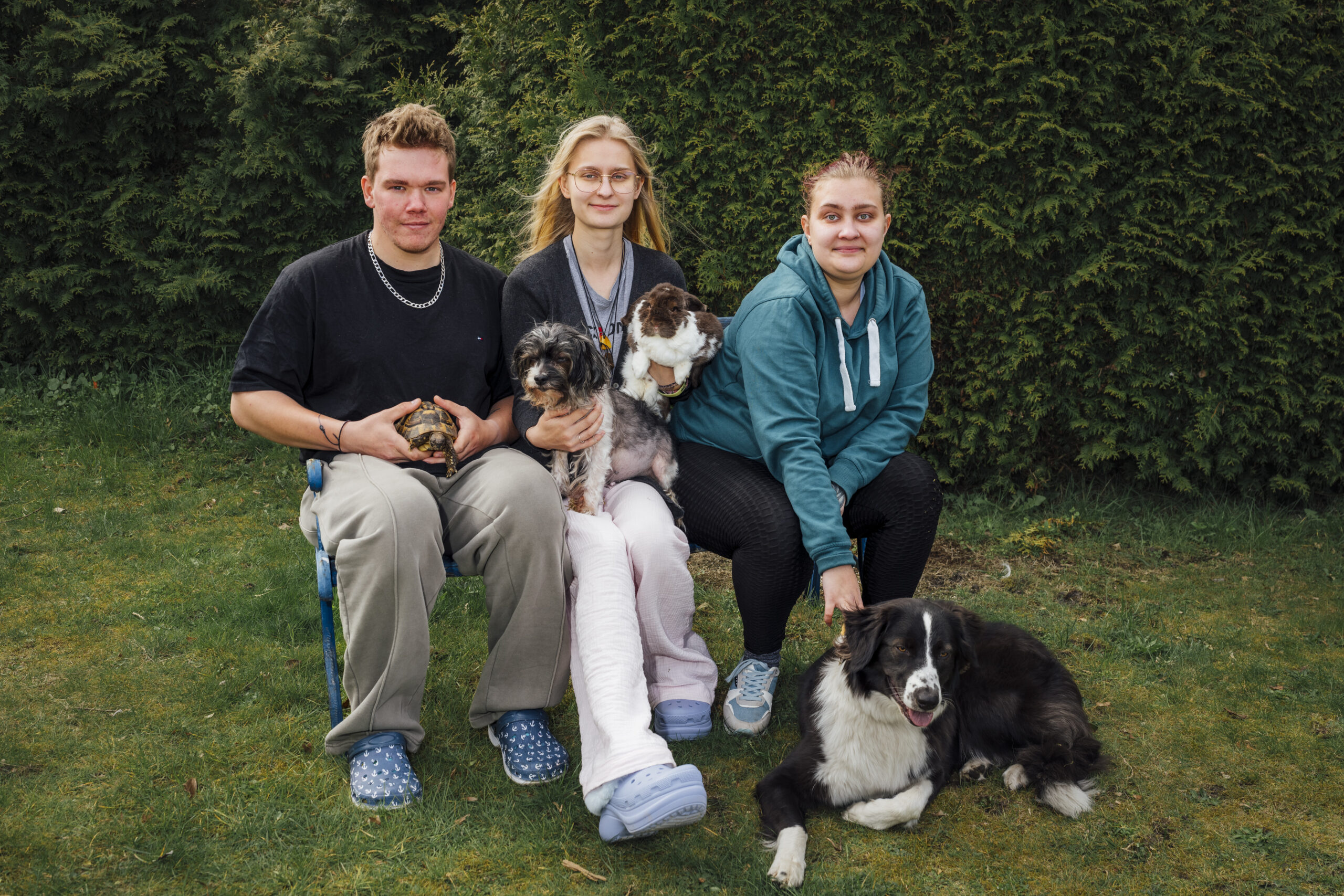 Drei junge Menschen mit Hunden.