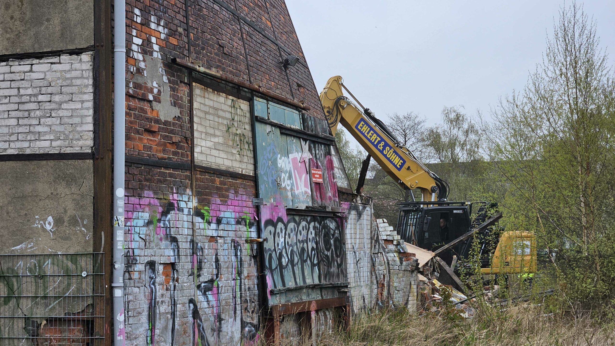 Bagger reißt Halle ab