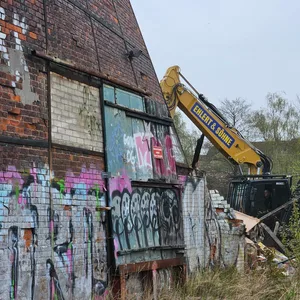 Bagger reißt Halle ab