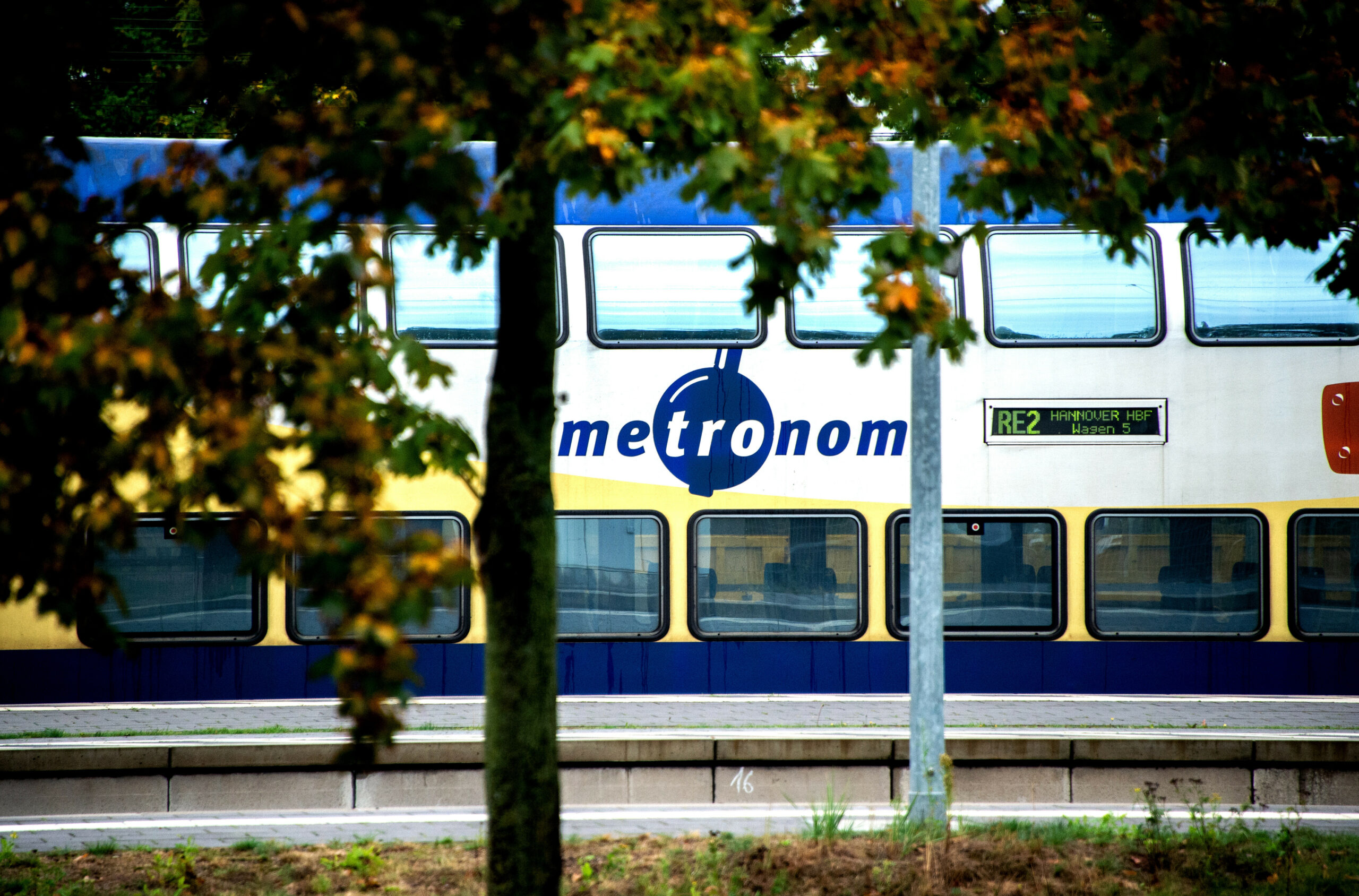Ein Zug der Metronom Eisenbahngesellschaft GmbH steht auf einem Gleis im Bahnhof.