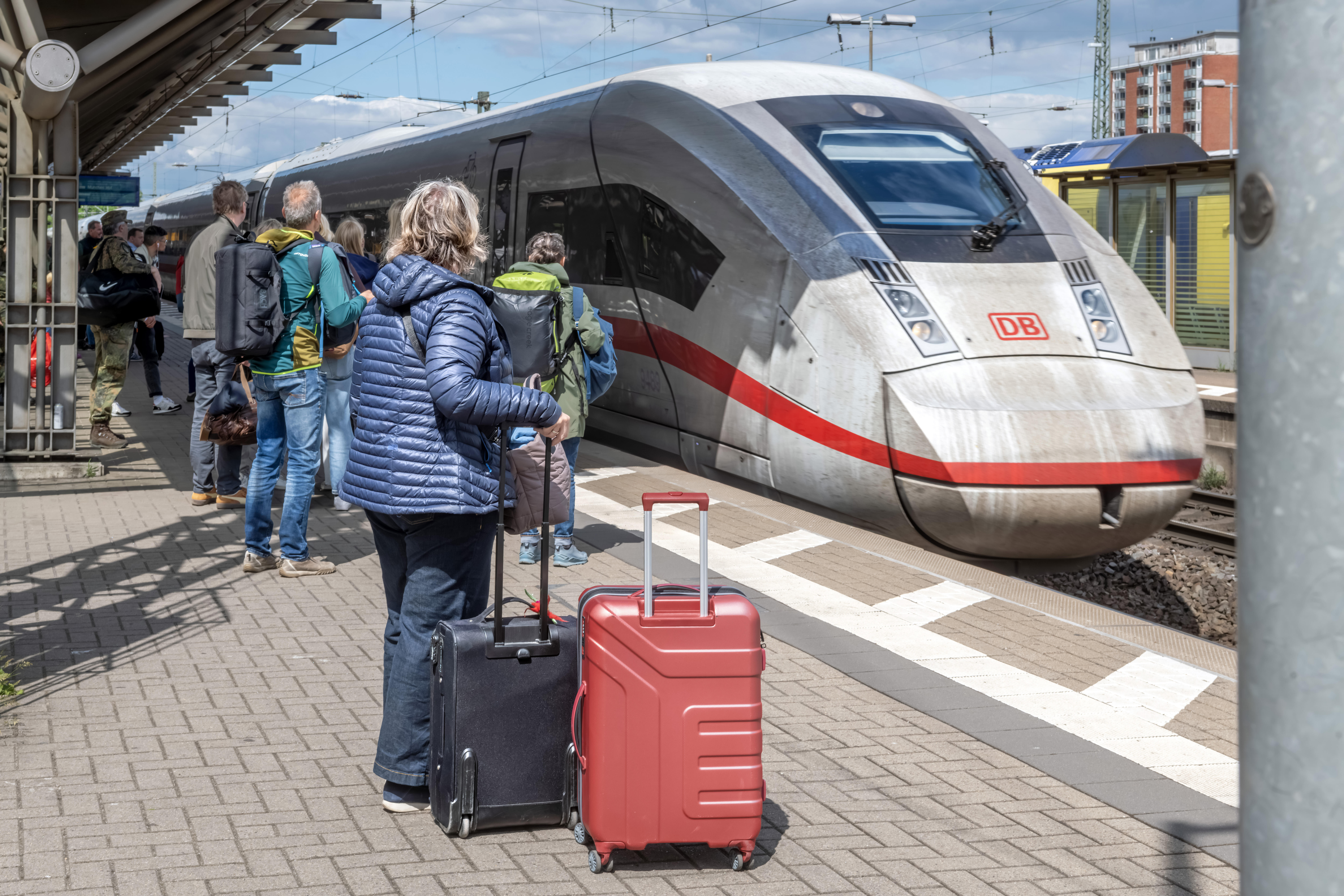 Zug und Reisende am Bahnhof