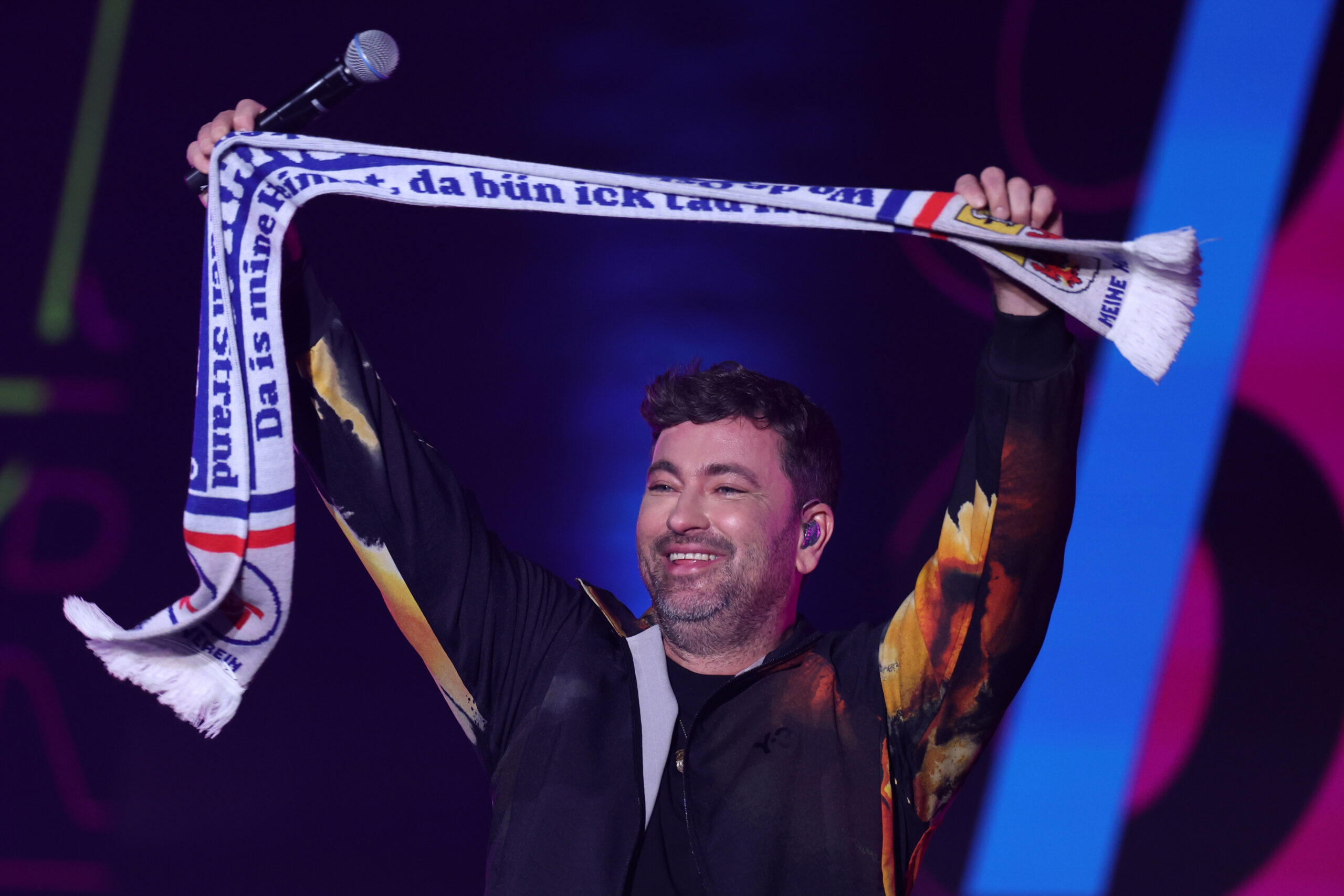 Marteria hält einen Fanschal von FC Hansa Rostock in die Höhe