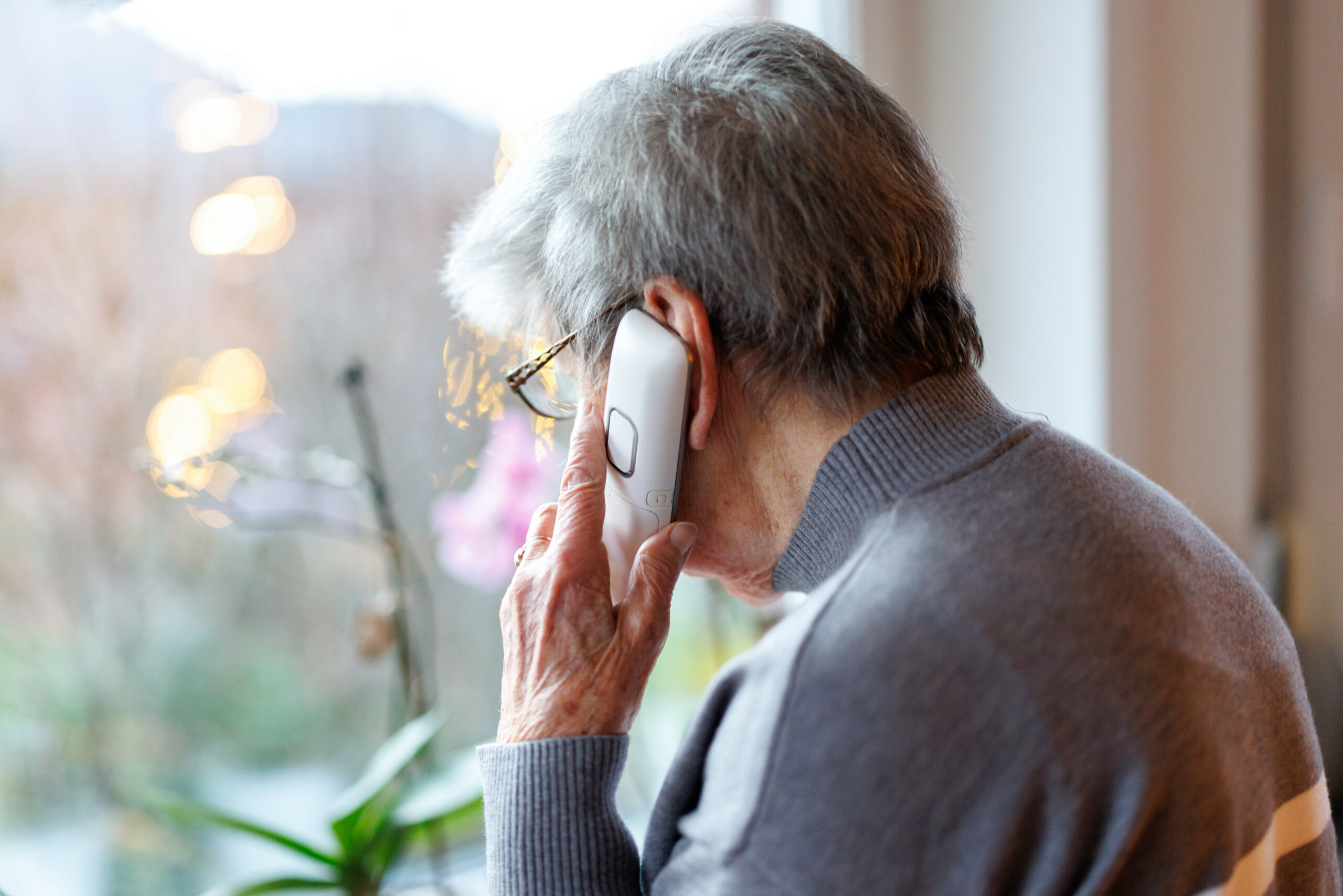 Eine Seniorin am Telefon. In Hamburg muss sich ein Angeklagter vor Gericht verantworten, weil er sich als falscher Polizist ausgegeben haben soll. (Symbolbild)