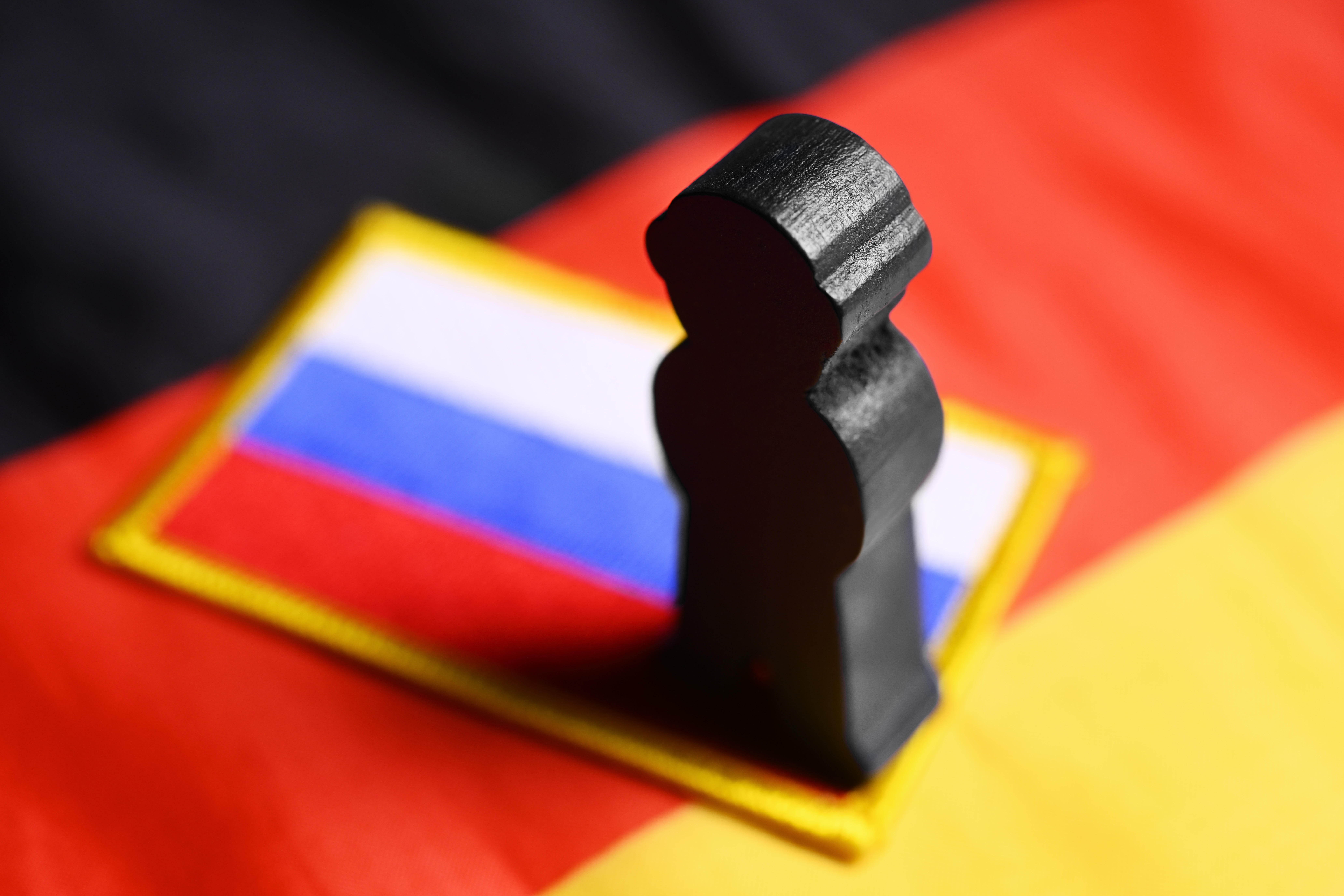 Figur vor Deutschland- und Russland-Flagge als Symbol für mutmaßliche russische Cyberangriffe auf Signal-Nutzer in Deutschland