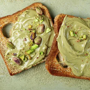 Zwei Scheiben Brot mit Pistaziencreme. Derzeit ruft ein Hersteller sein Produkt zurück – es könnte mit Salmonellen belastet sein. (Symbolbild)