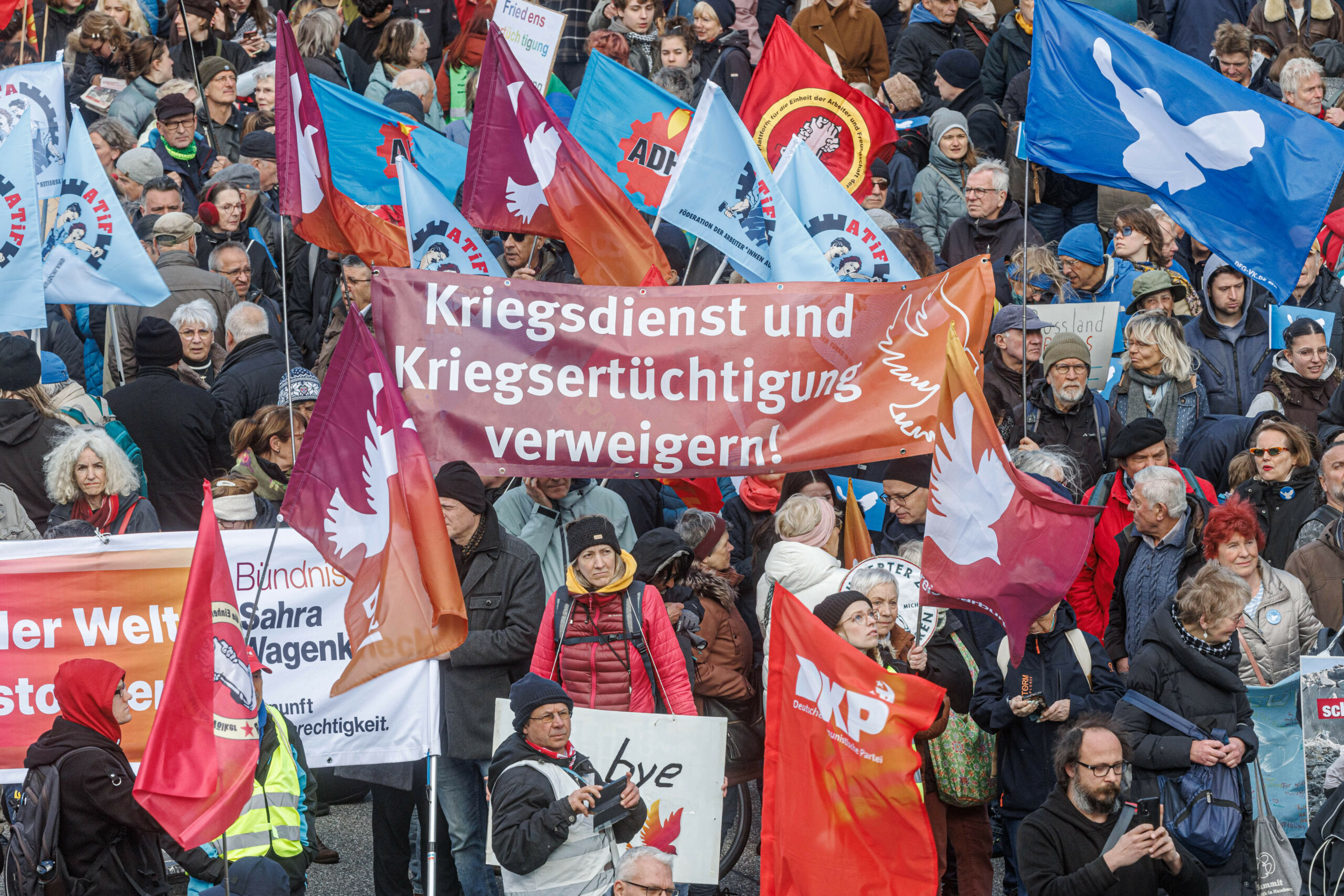 Demonstranten haben Fahnen und Plakate beim Ostermarsch 2026 dabei.