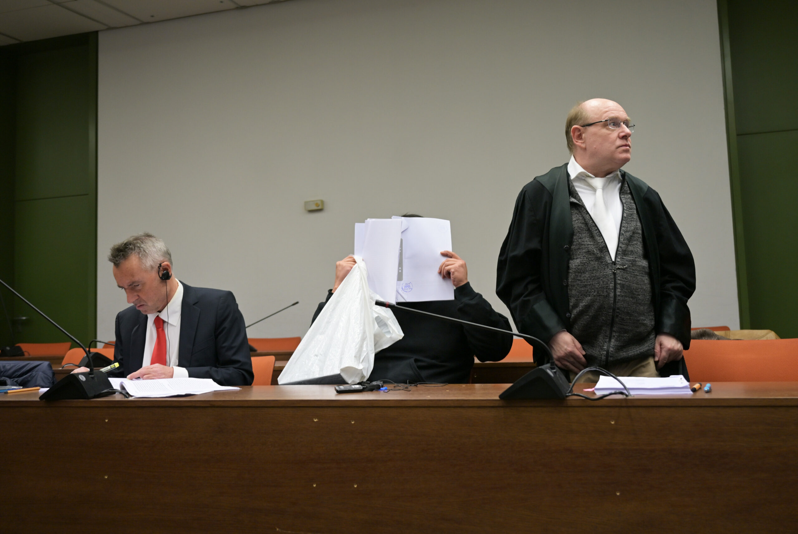 Der Angeklagte im Prozess wegen versuchten Mordes und Vergewaltigung sitzt zwischen seinem Dolmetscher (l) und seinem Anwalt (r). Er soll seine Nachbarin, mit der er eine sexuelle Beziehung hatte, mehrfach mit schweren Betäubungsmedikamenten sediert, vergewaltigt und dabei gefilmt haben.
