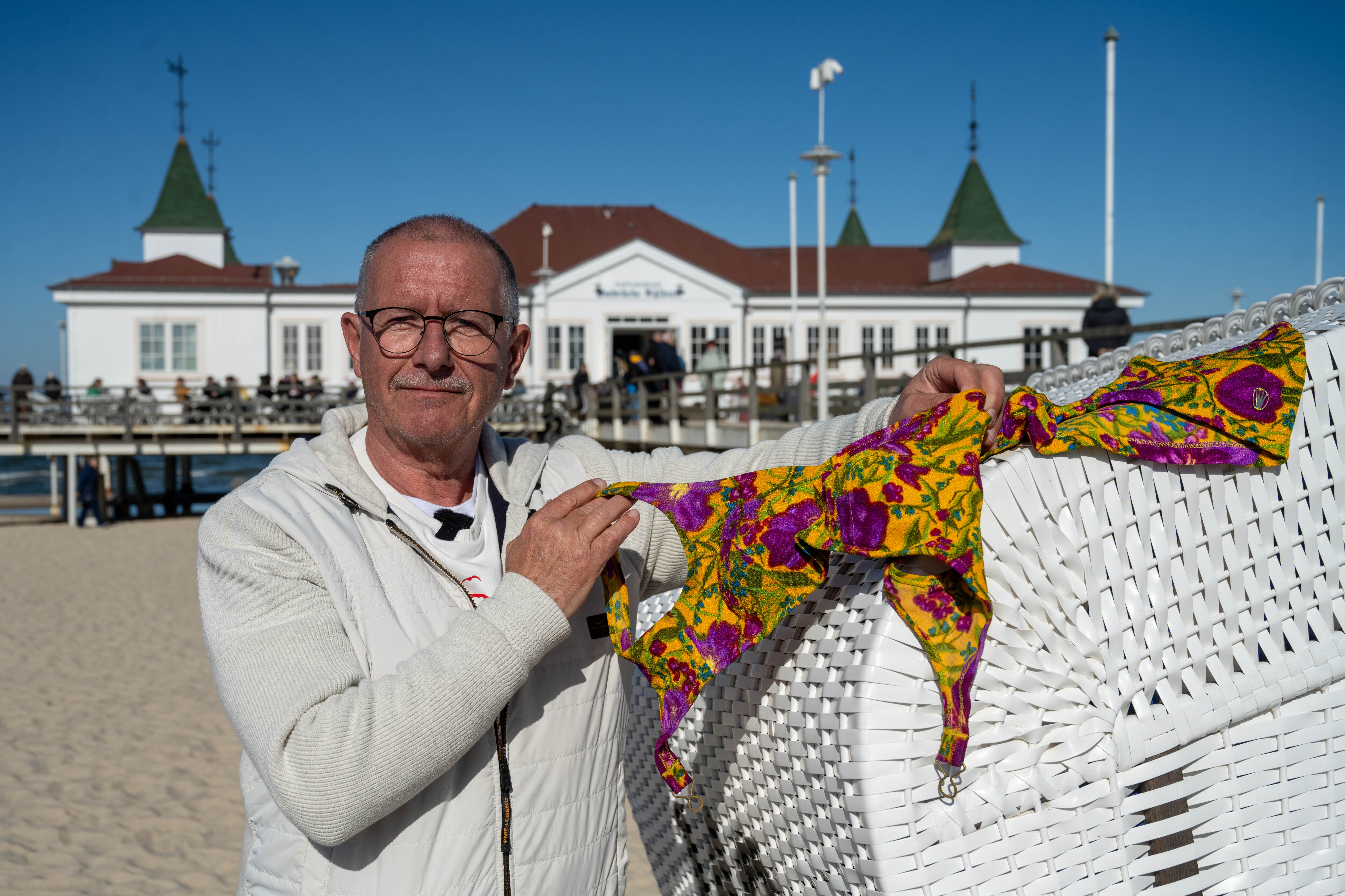 Jürgen Kraft zeigt vor der Seebrücke Ahlbeck einen Bikini des französischen Modeschöpfers Réard.