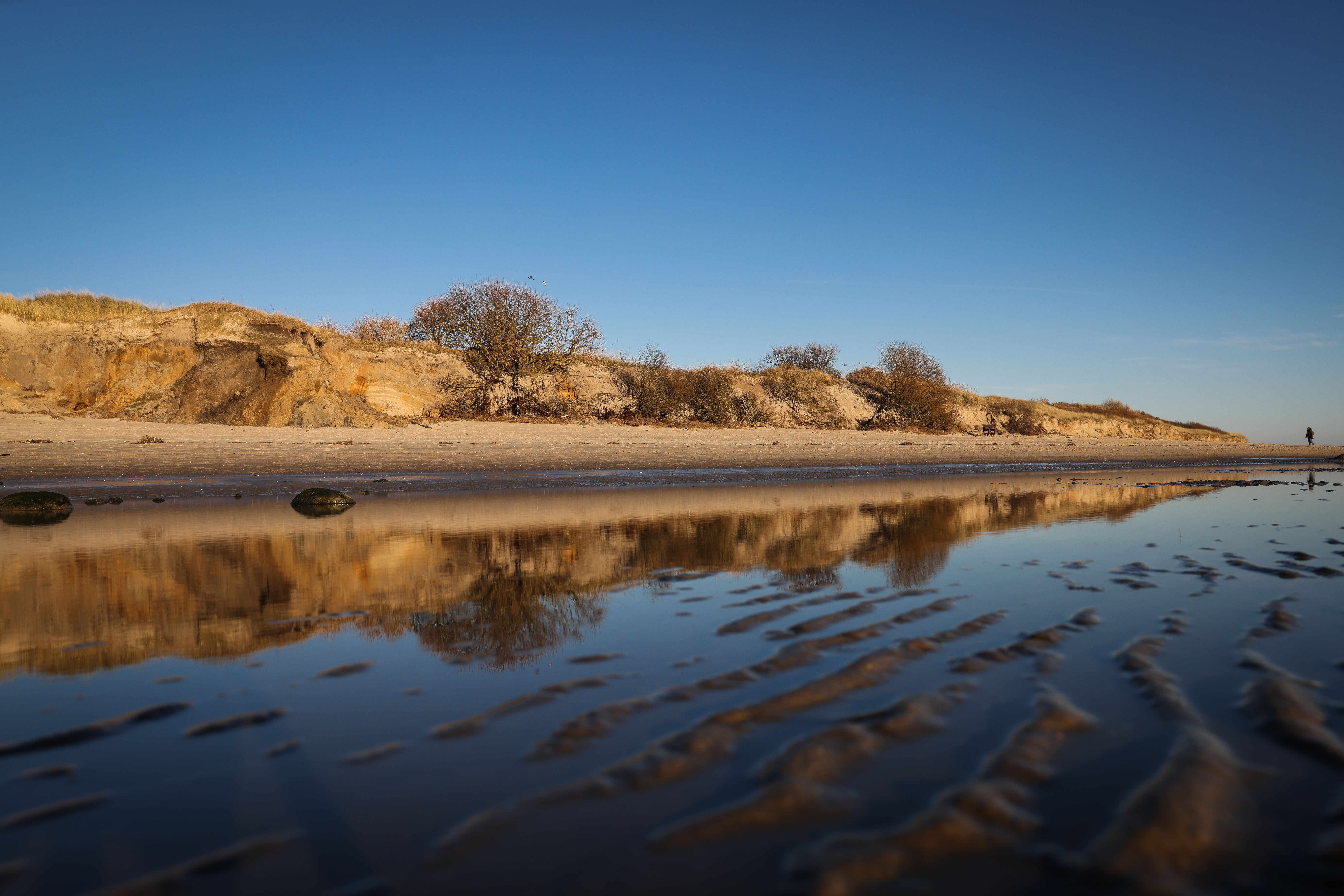 Mutterboden ist hinter den weggespülten Sanddünen am Strand zwischen Gotinger Cliff und FKK-Strand auf der Nordseeinsel Föhr zu sehen – jetzt soll frischer Sand her.
