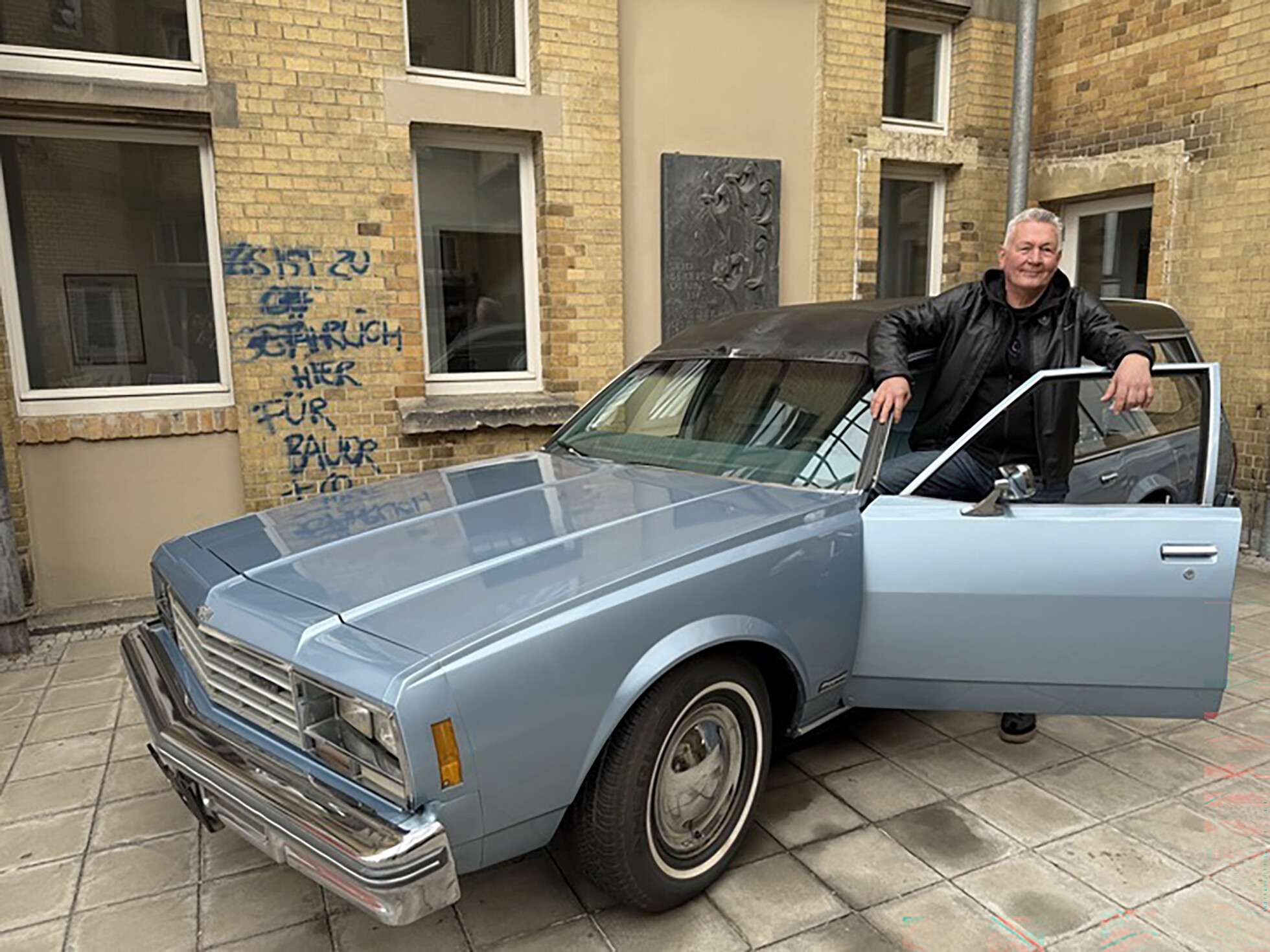 Gerold Eppler, stellvertretender Leiter des Museums für Sepulkralkultur, steht neben einem zum Bestattungswagen umgebauten Chevrolet Impala.
