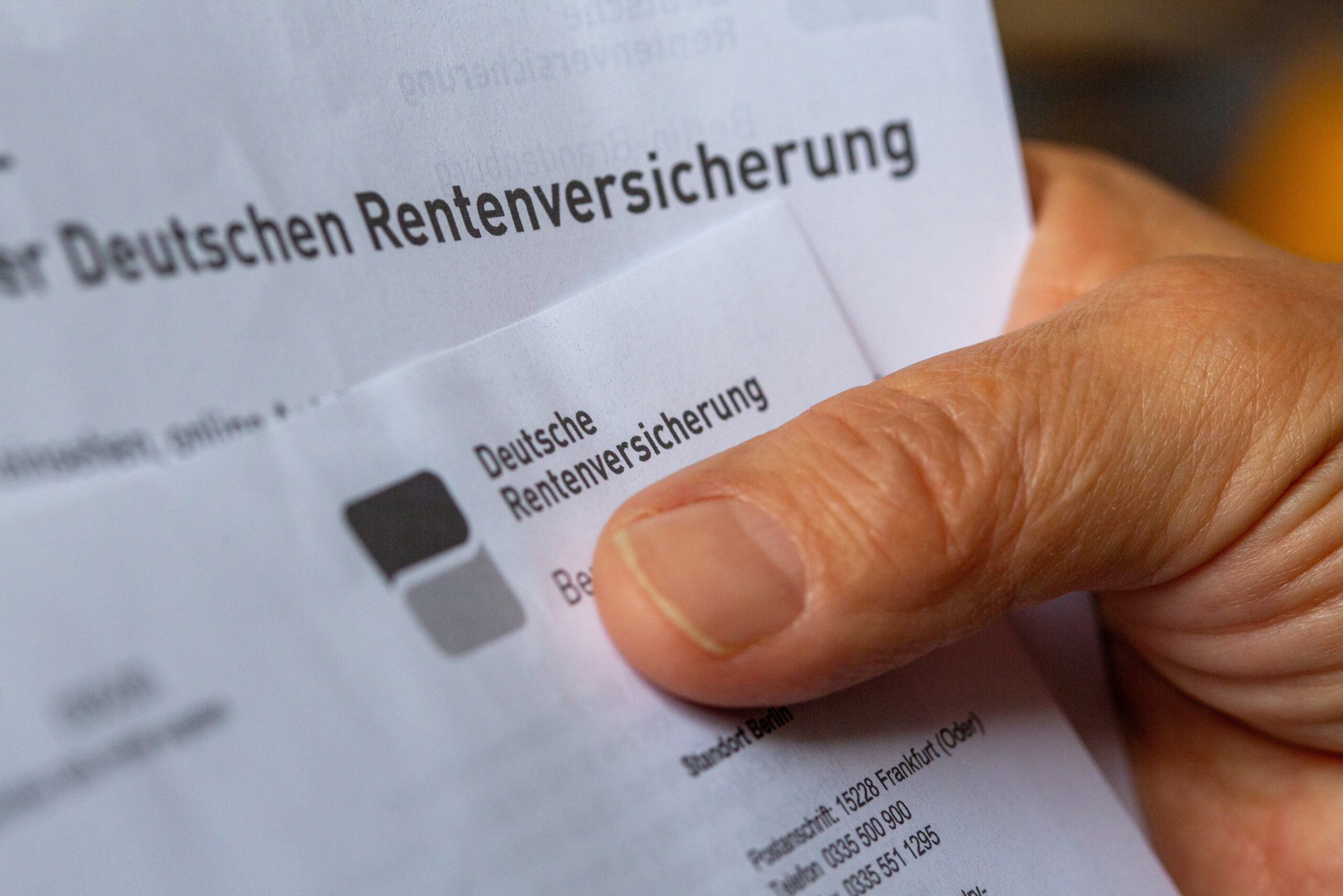 Eine Seniorin hält ein Schreiben der Deutschen Rentenversicherung in der Hand. Die gesetzliche Rente wird immer geringer.