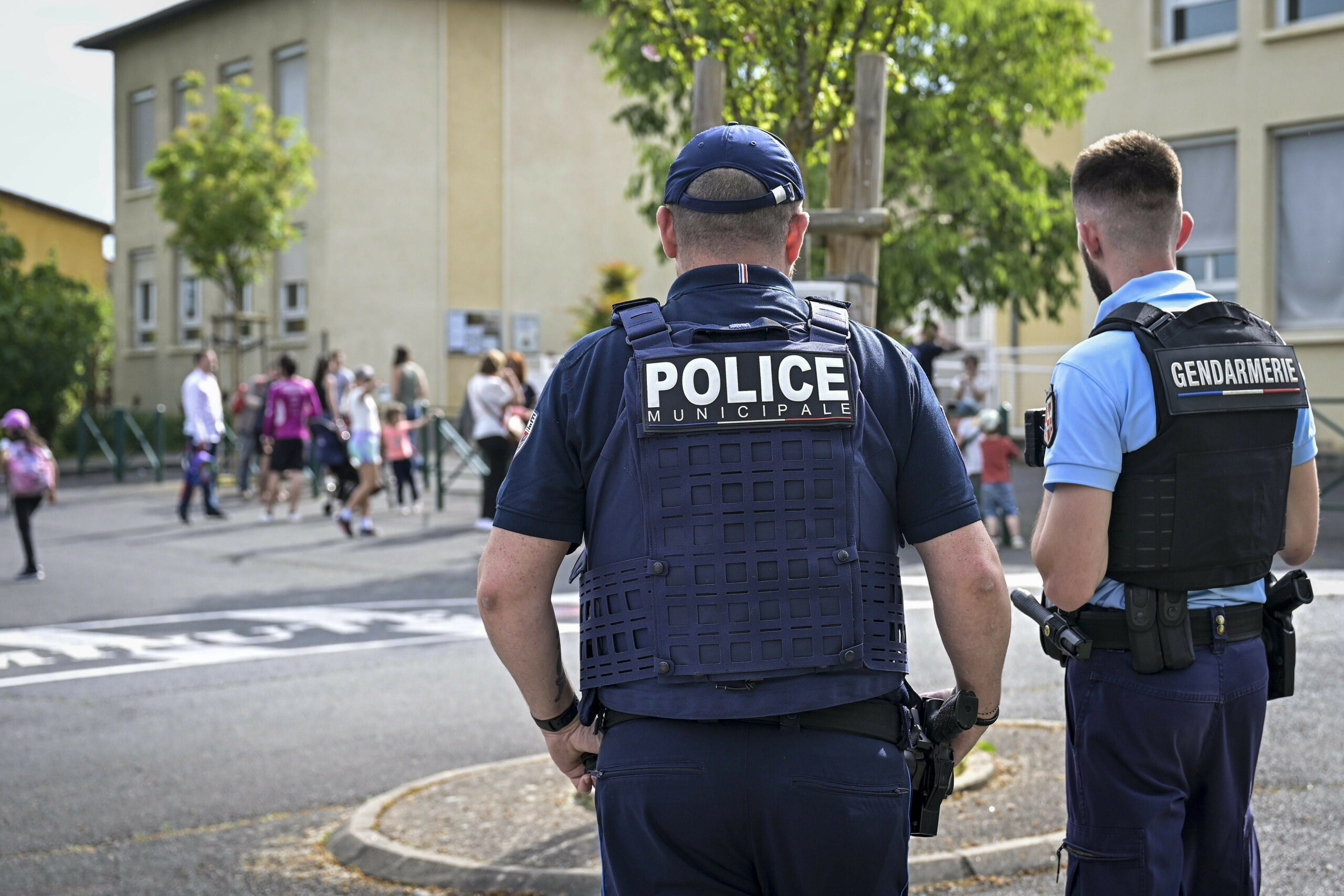 Polizisten stehen vor der Schule in Lucenay.