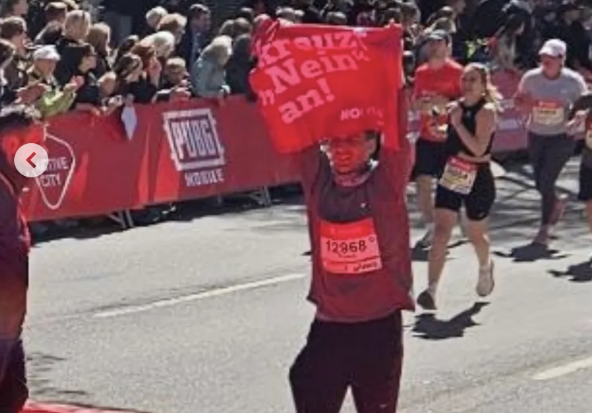 Der Läufer mit Anti-Olympia-Fahne beim Haspa-Marathon in Hamburg.
