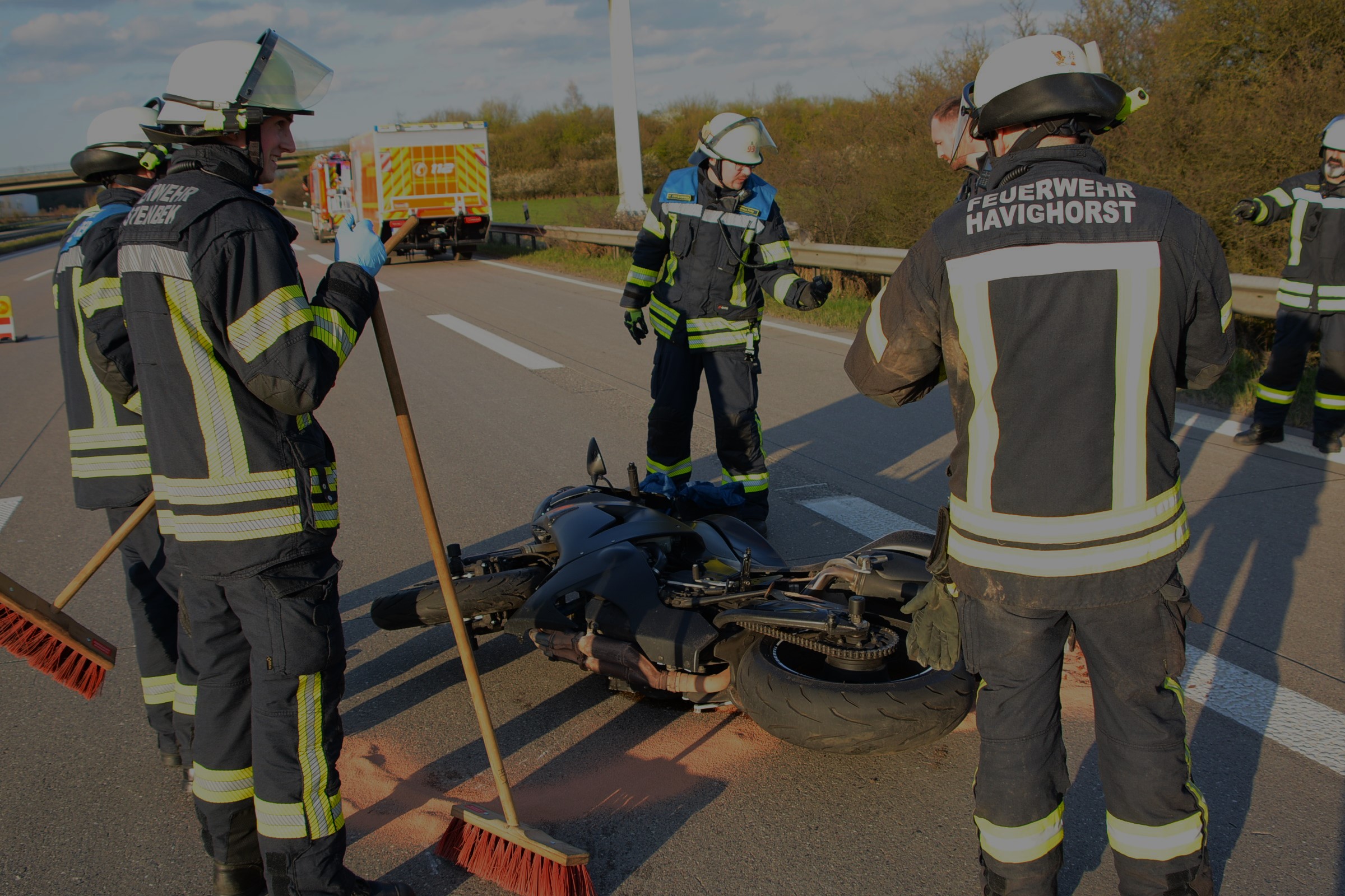 Feuerwehrleute um eine Motorrad