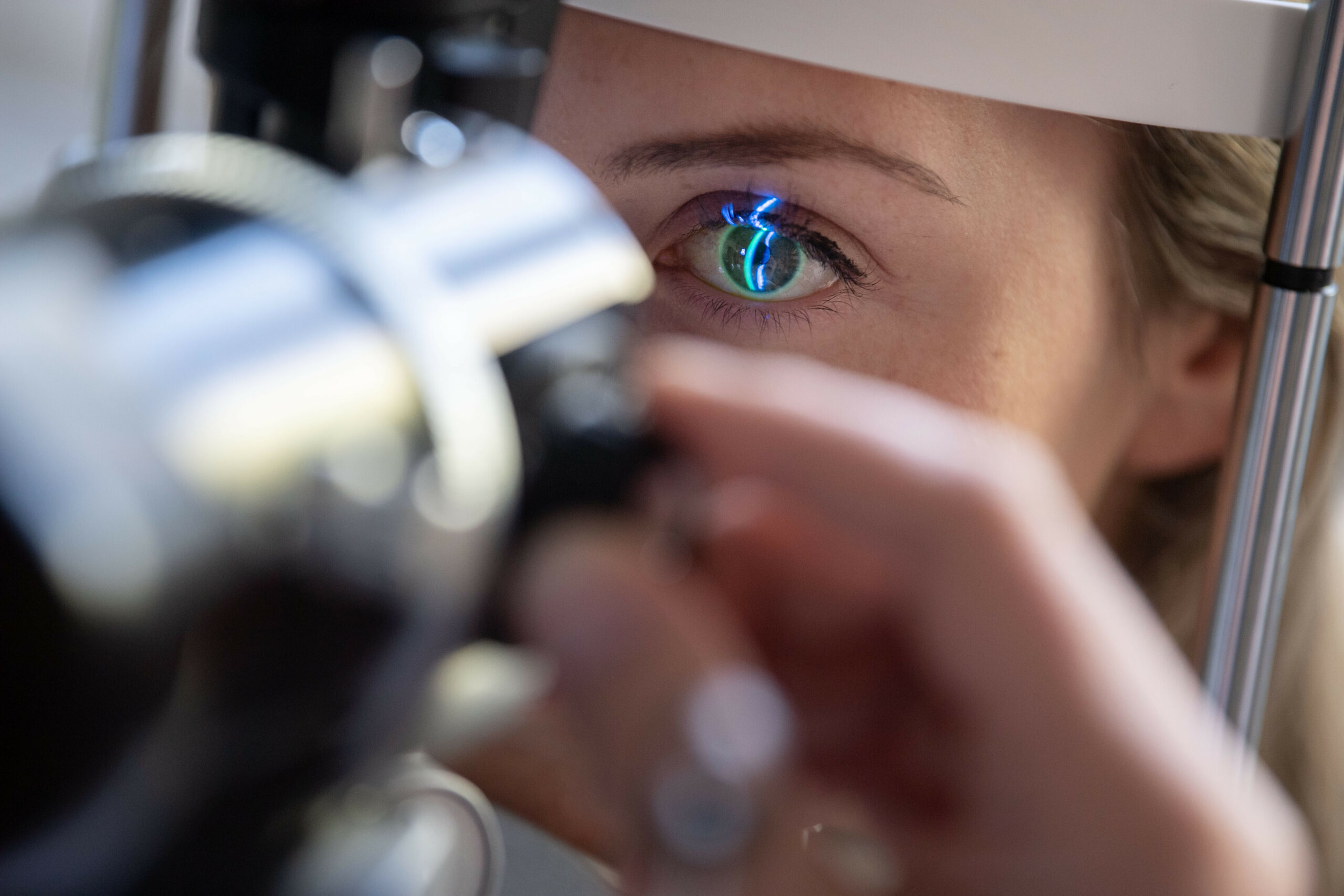 Ein Arzt untersucht das Auge einer Patientin.