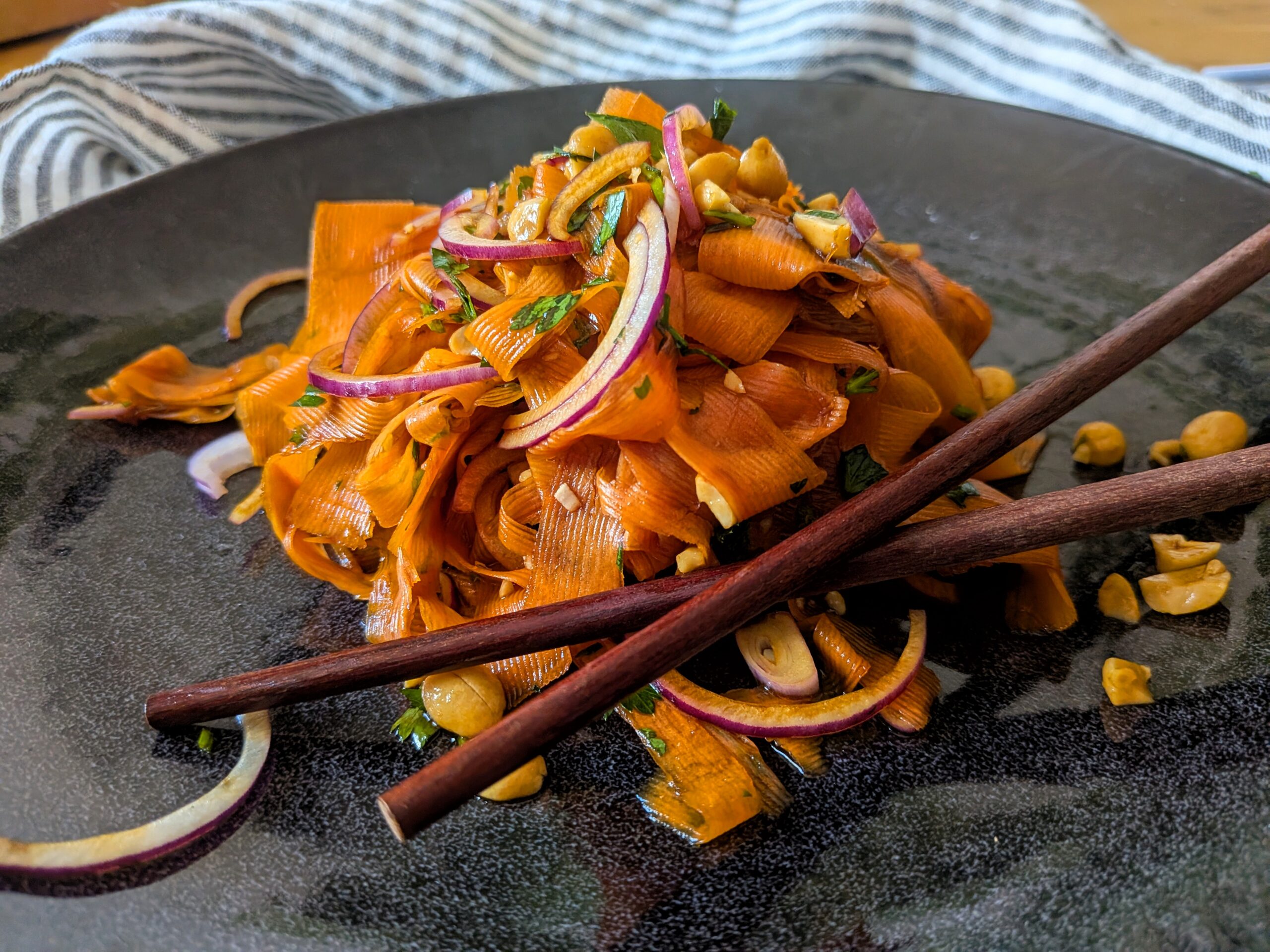 Ein Teller mit Karottensalat im Asia-Style steht auf dem Tisch