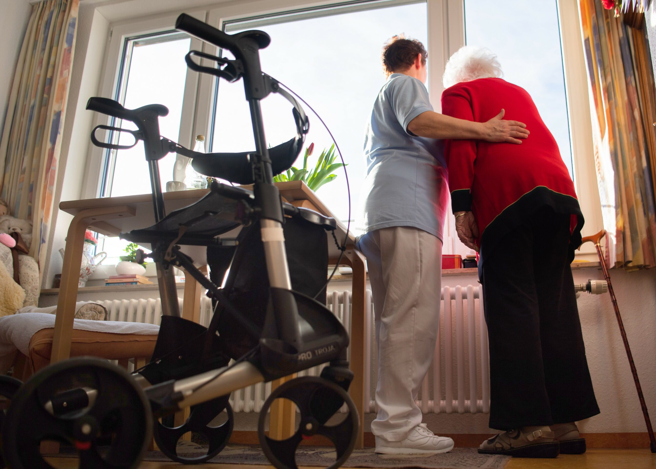 Eine Pflegerin unterstützt eine Heimbewohnerin