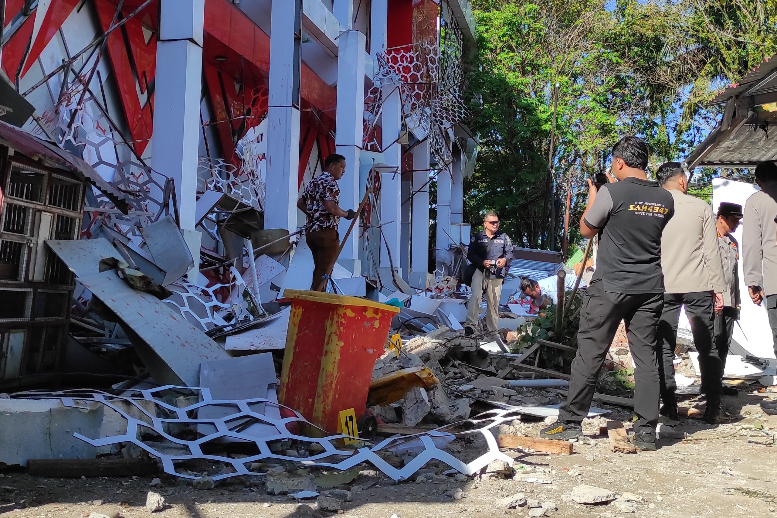 Polizisten inspizieren ein beschädigtes Gebäude nach einem Erdbeben in Manado, Sulawesi, Indonesien.