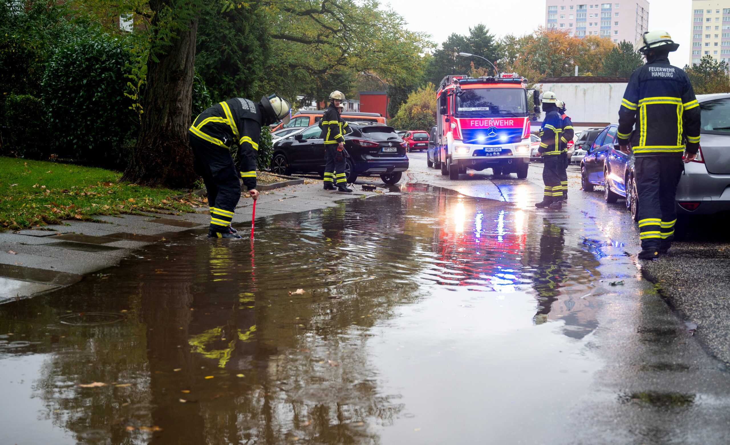 Feuerwehrleute auf einer überschwemmten Straße in Hamburg-Lohbrügge (Archivbild).