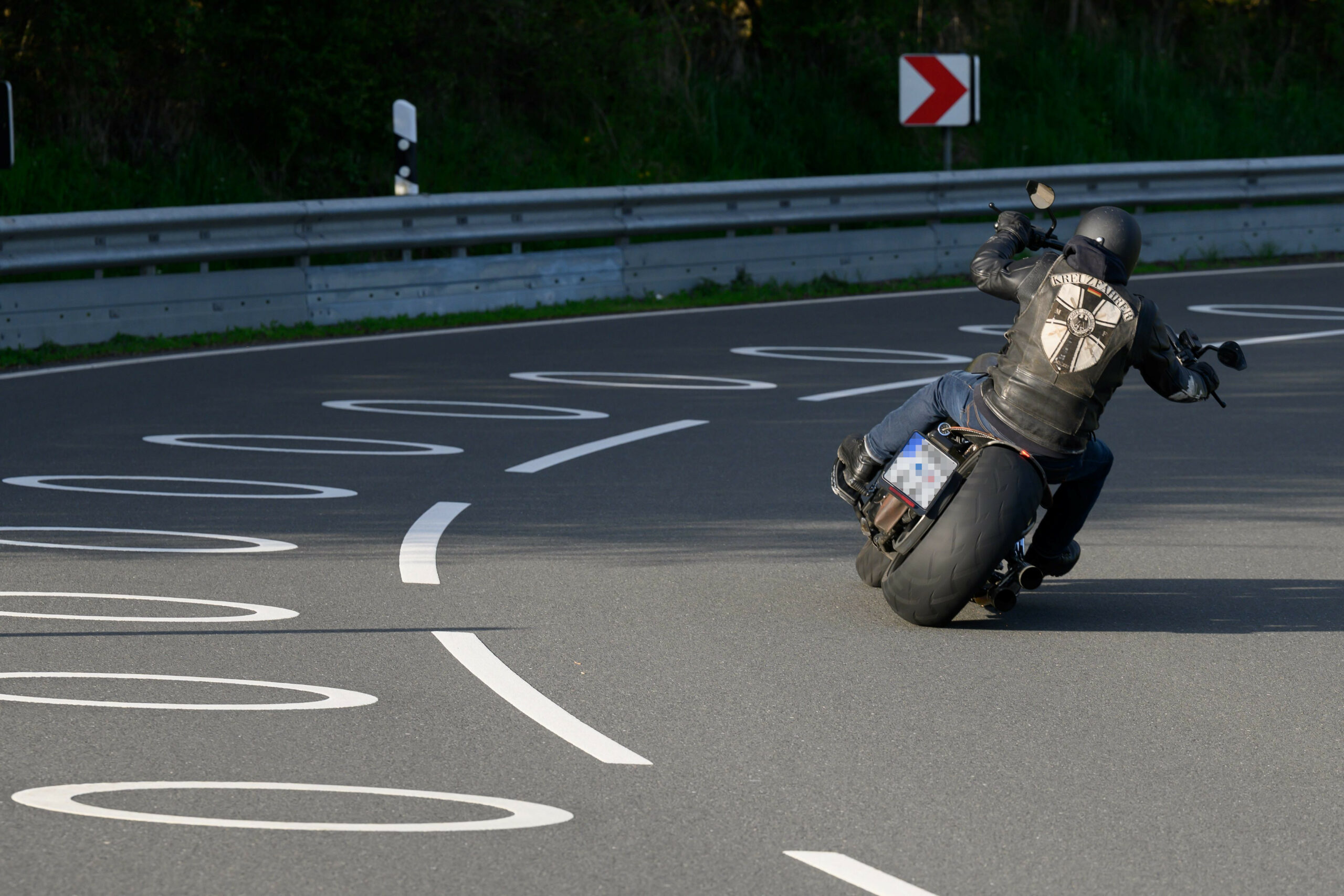 Ein Motorradfahrer fährt durch eine mit Kreis-Markierungen versehene Kurve auf der Bundesstraße 3 bei Scheden.