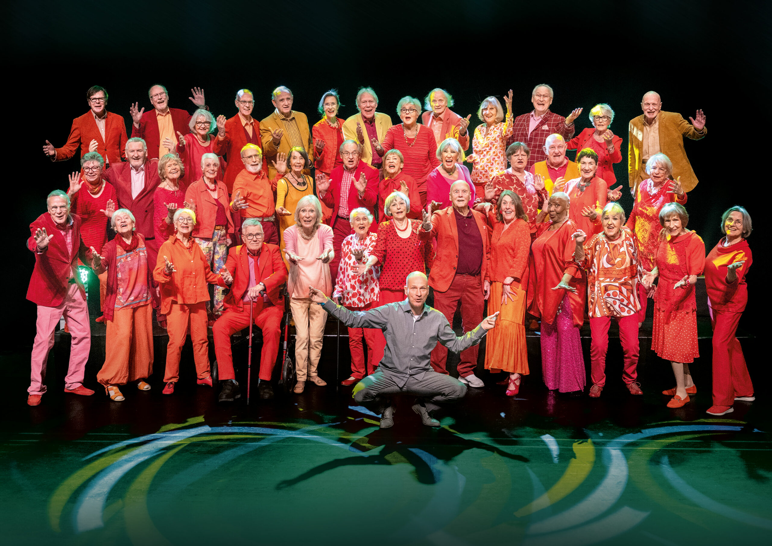 Die Sängerinnen und Sänger des Chors „Heaven Can Wait“ stehen in Rot gekleidet nebeneinander.