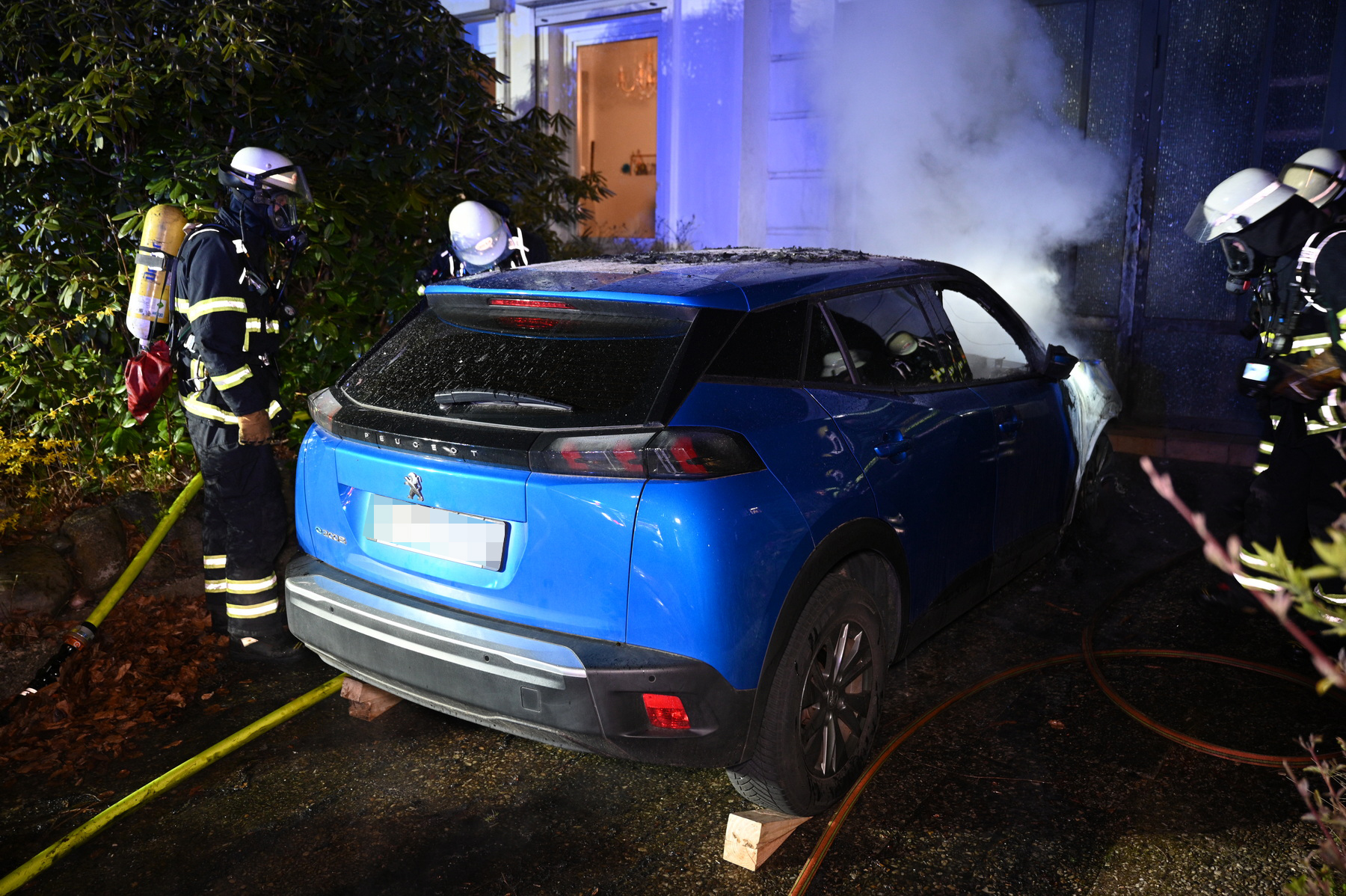 Feuerwehrleute im Einsatz, um das E-Auto zu löschen.